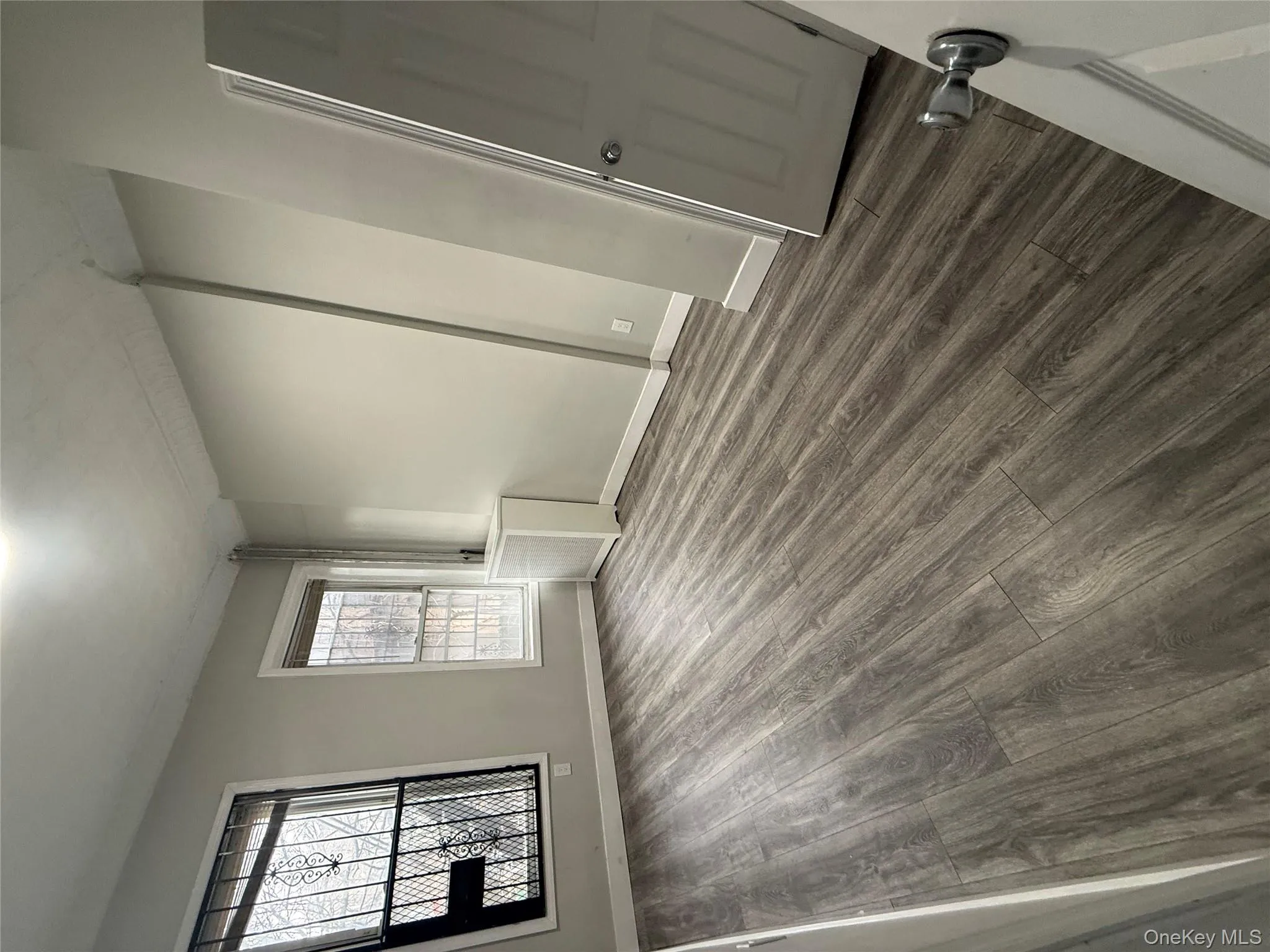 Empty room with dark wood-style floors and baseboards Empty room with dark wood-style floors and baseboards