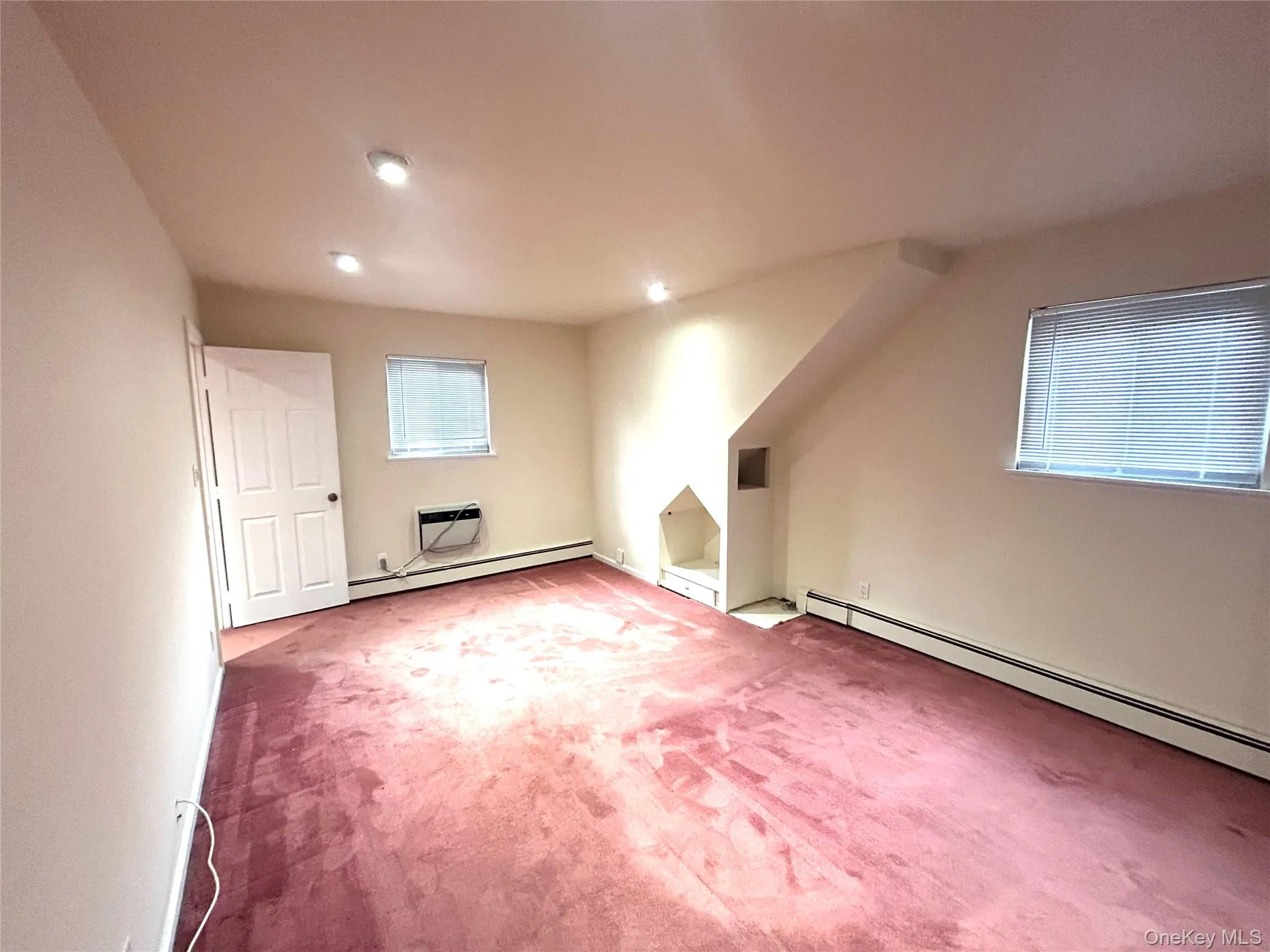 Bonus room with carpet flooring, baseboard heating, an AC wall unit, and recessed lighting Bonus room with carpet flooring, baseboard heating, an AC wall unit, and recessed lighting