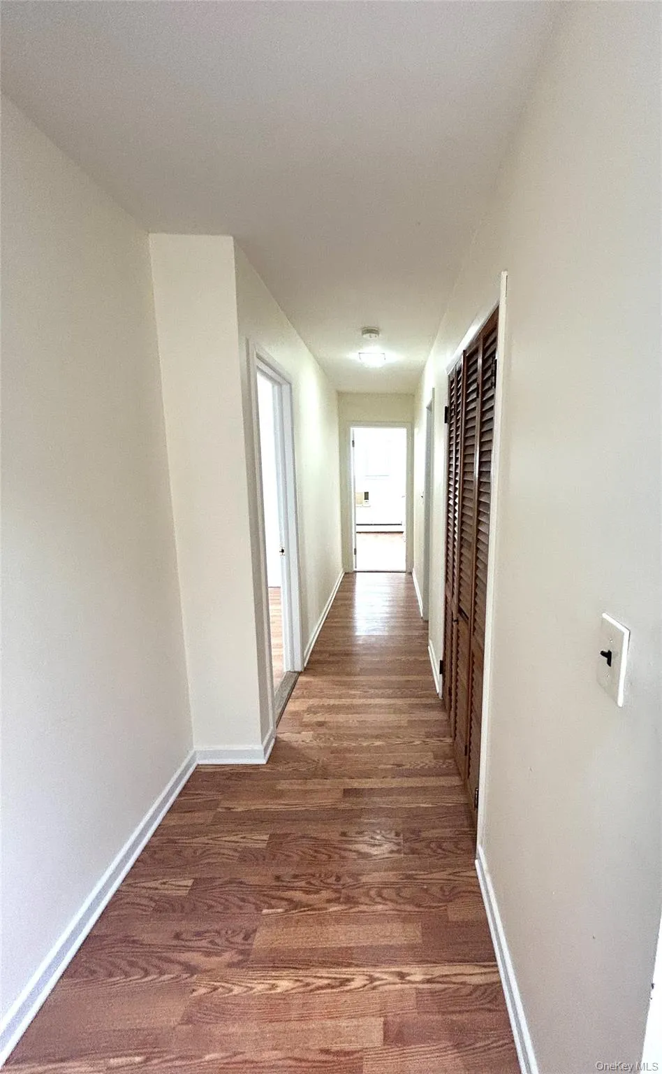Hall with dark wood finished floors and a heating unit Hall with dark wood finished floors and a heating unit