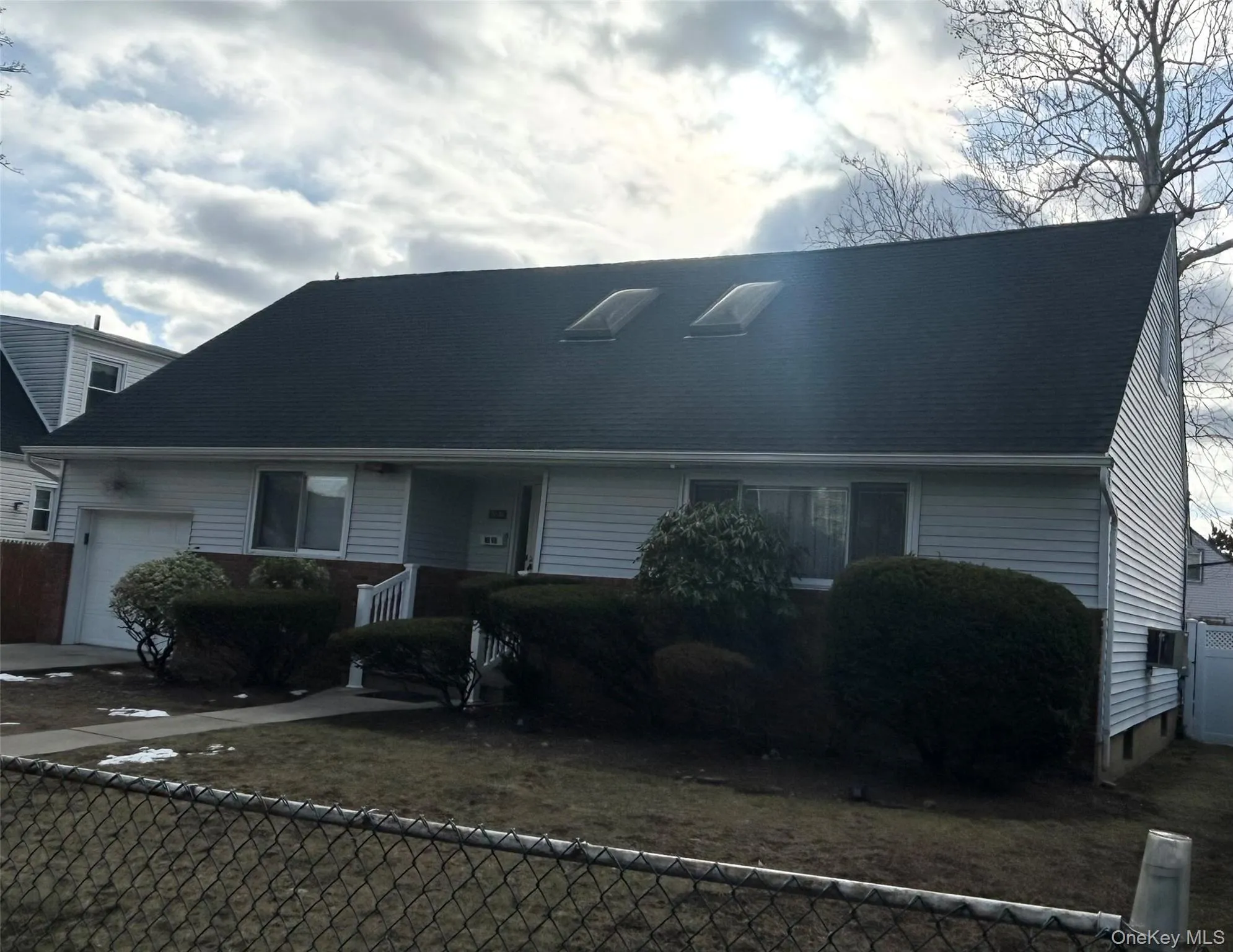 View of front of house with a fenced front yard, an attached garage, and driveway View of front of house with a fenced front yard, an attached garage, and driveway
