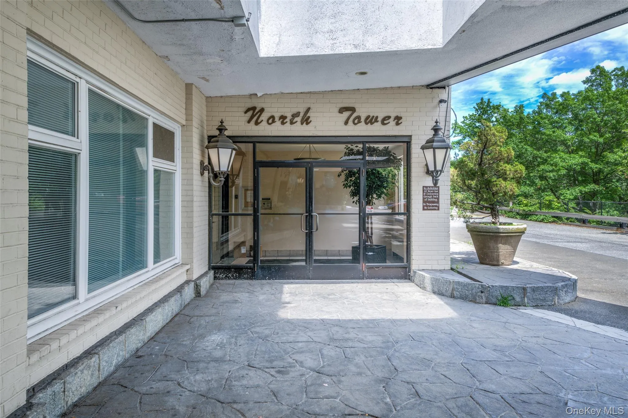 Entrance to property featuring brick siding and a patio area Entrance to property featuring brick siding and a patio area