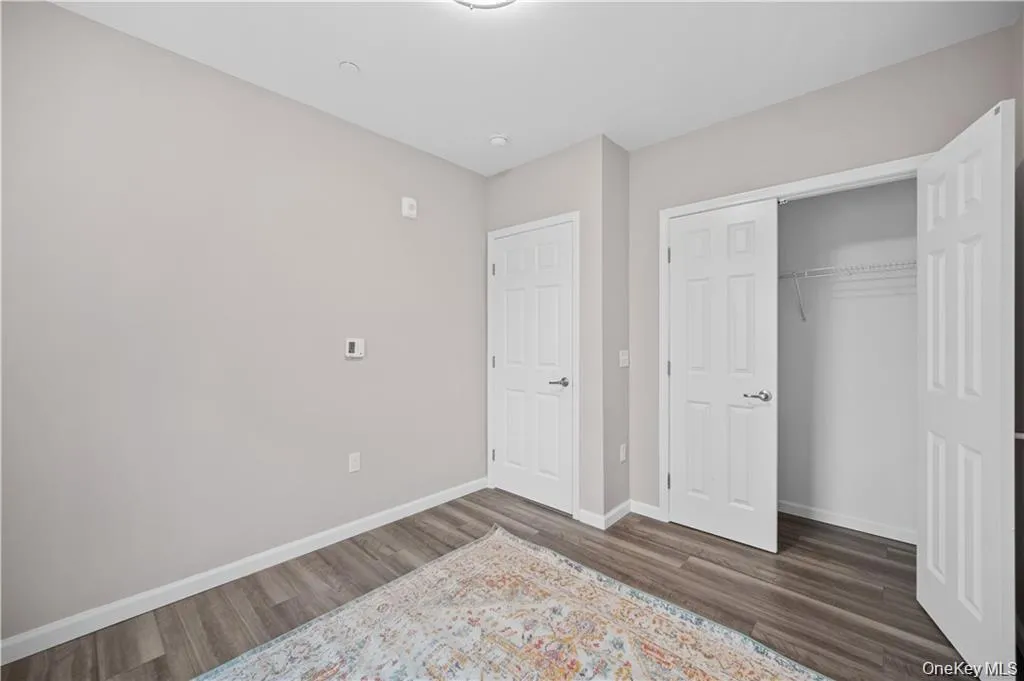 Unfurnished bedroom with a closet and dark wood-style floors Unfurnished bedroom with a closet and dark wood-style floors