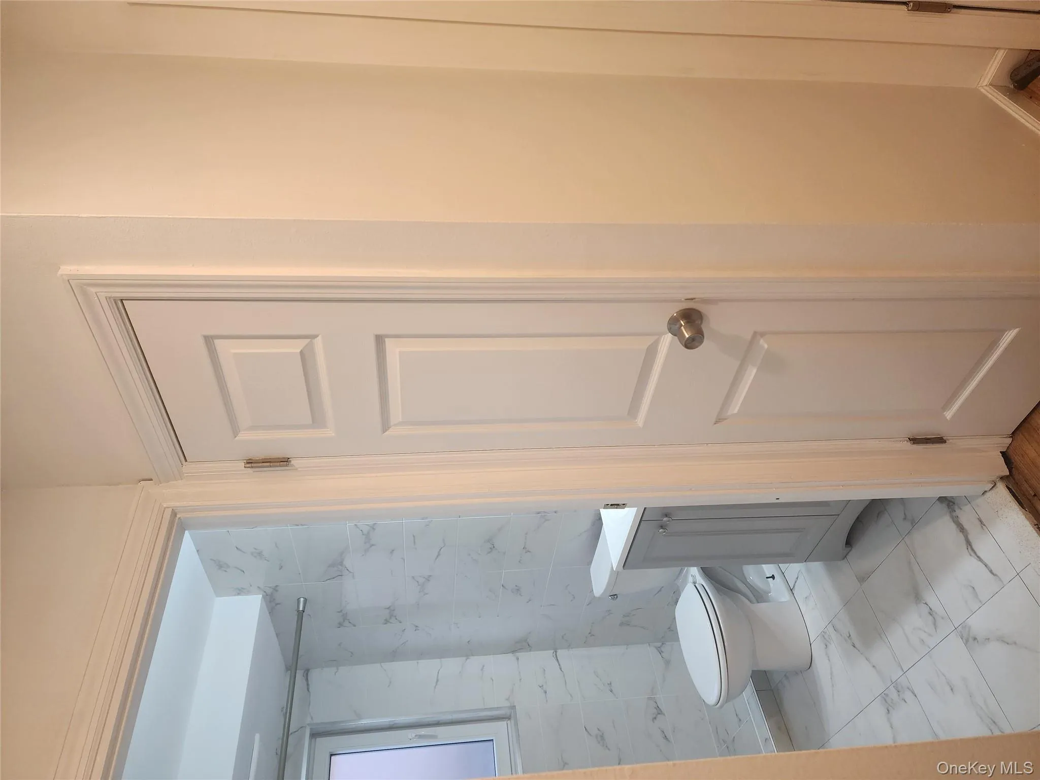 Bathroom featuring light marble finish flooring, vanity, tile walls, and a marble finish shower Bathroom featuring light marble finish flooring, vanity, tile walls, and a marble finish shower