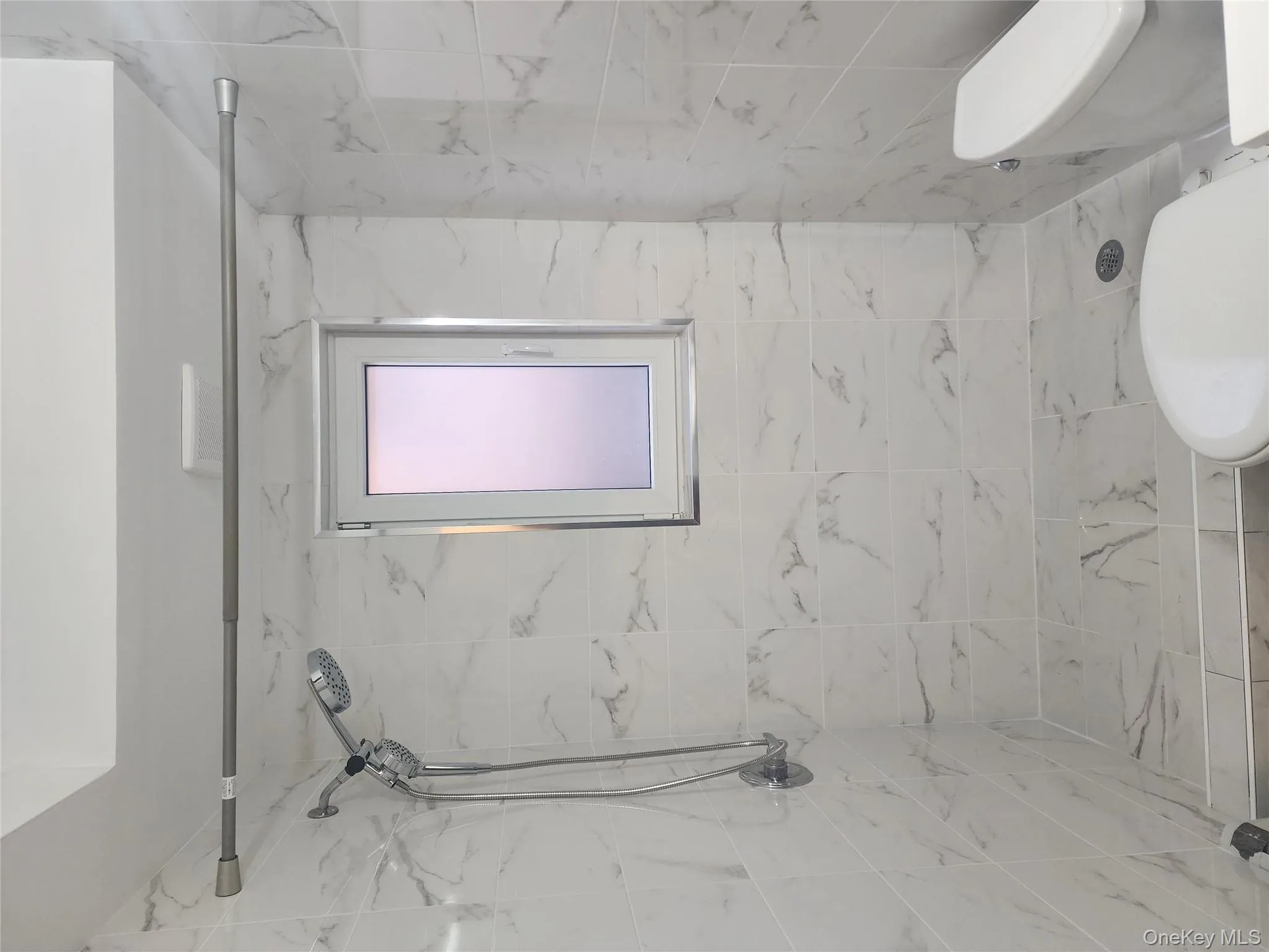 Full bath with a marble finish shower and toilet Full bath with a marble finish shower and toilet