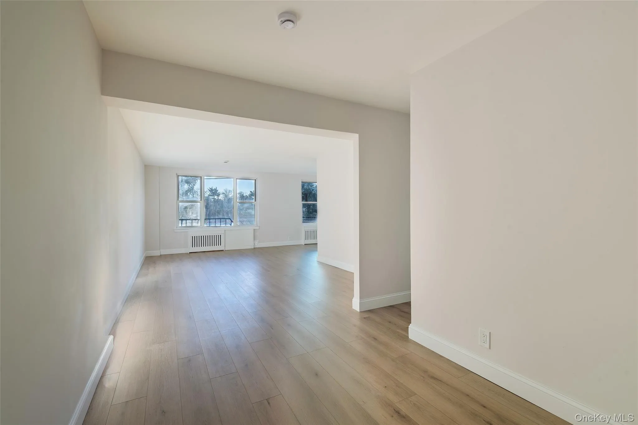 Unfurnished room with light wood-type flooring and radiator Unfurnished room with light wood-type flooring and radiator