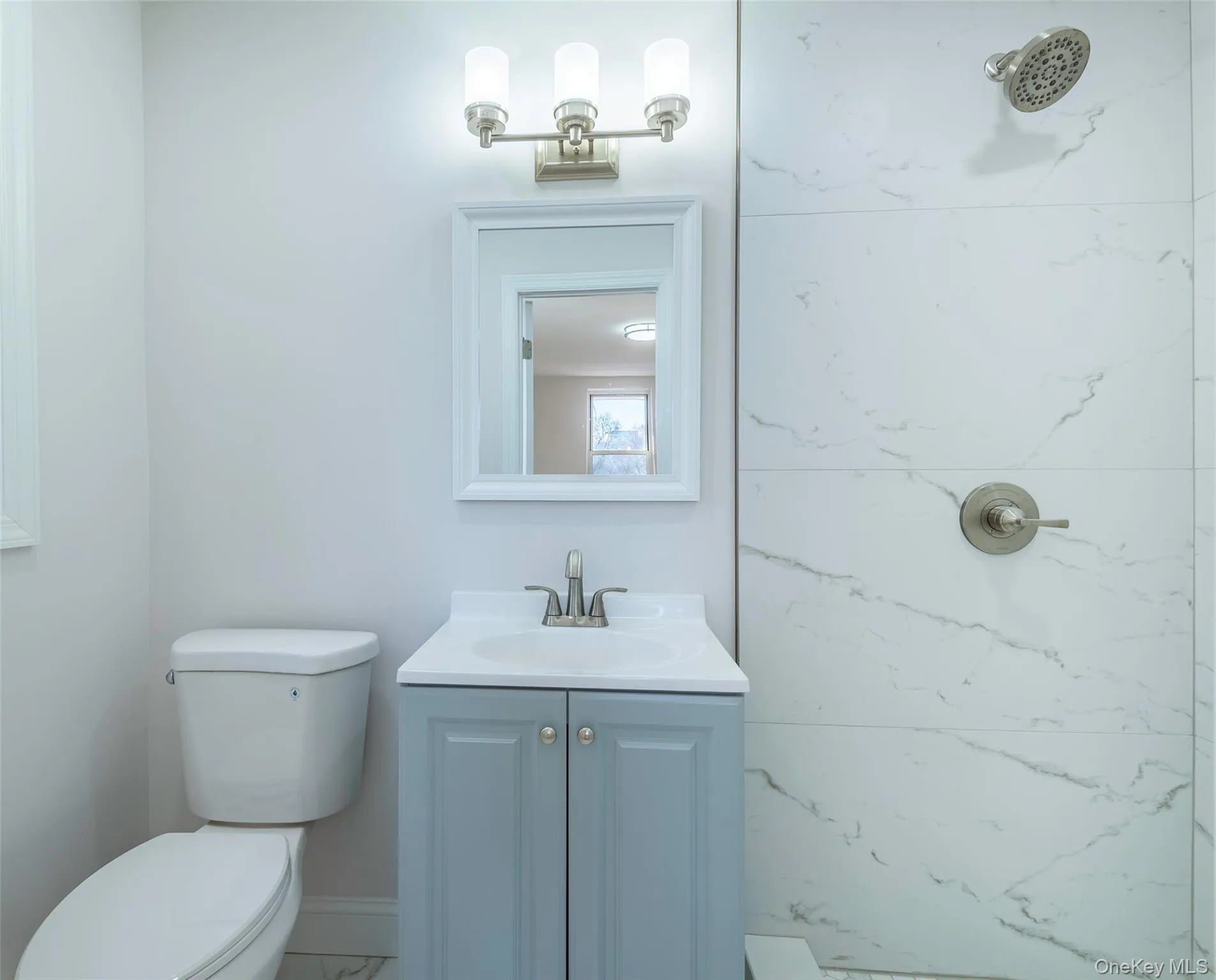 Full bathroom featuring vanity, a marble finish shower, and marble finish floors Full bathroom featuring vanity, a marble finish shower, and marble finish floors