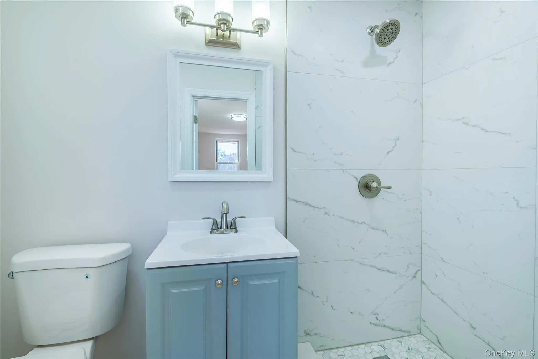 Full bath featuring a marble finish shower and vanity Full bath featuring a marble finish shower and vanity