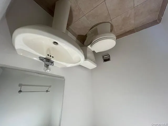 Bathroom featuring toilet and light tile patterned floors Bathroom featuring toilet and light tile patterned floors