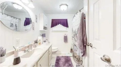 Full bathroom featuring curtained shower, vanity, and light tile patterned floors Full bathroom featuring curtained shower, vanity, and light tile patterned floors