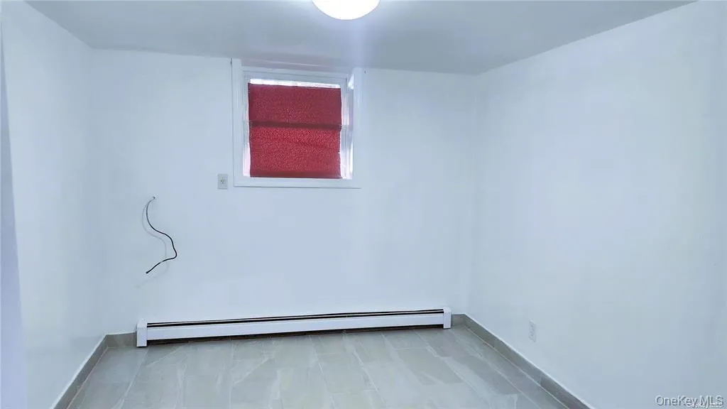 Unfurnished room with a baseboard heating unit and baseboards Unfurnished room with a baseboard heating unit and baseboards