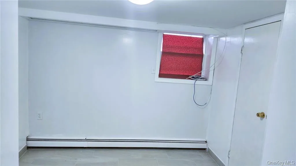 Unfurnished room with a baseboard radiator Unfurnished room with a baseboard radiator