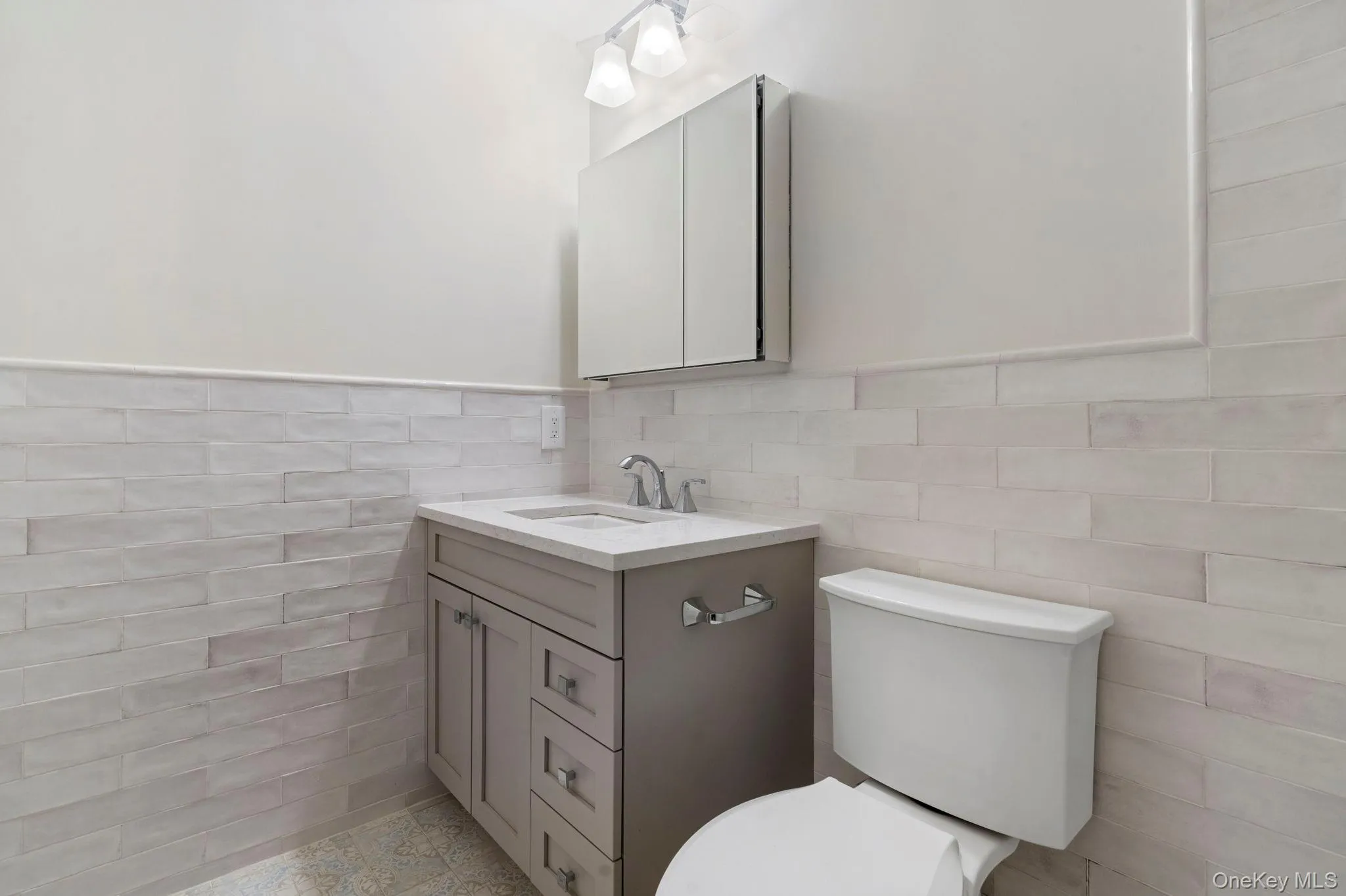 Bathroom with tile walls, wainscoting, and vanity Bathroom with tile walls, wainscoting, and vanity