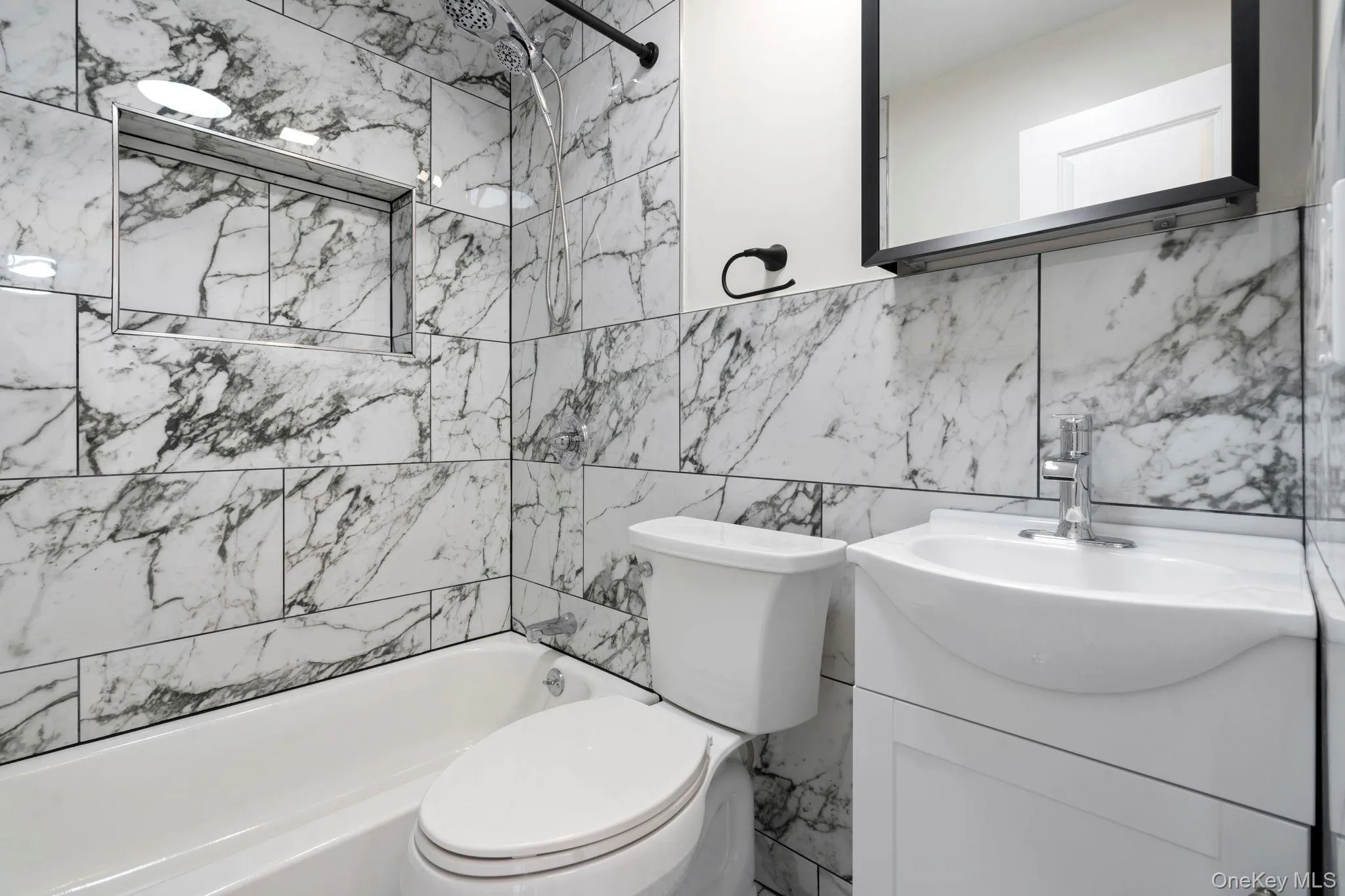 Bathroom with tile walls, vanity, and tub / shower combination Bathroom with tile walls, vanity, and tub / shower combination
