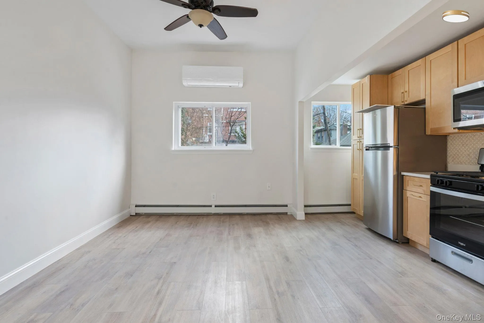 Kitchen featuring stainless steel appliances, light brown cabinetry, light wood-style floors, light countertops, and ceiling fan Kitchen featuring stainless steel appliances, light brown cabinetry, light wood-style floors, light countertops, and ceiling fan