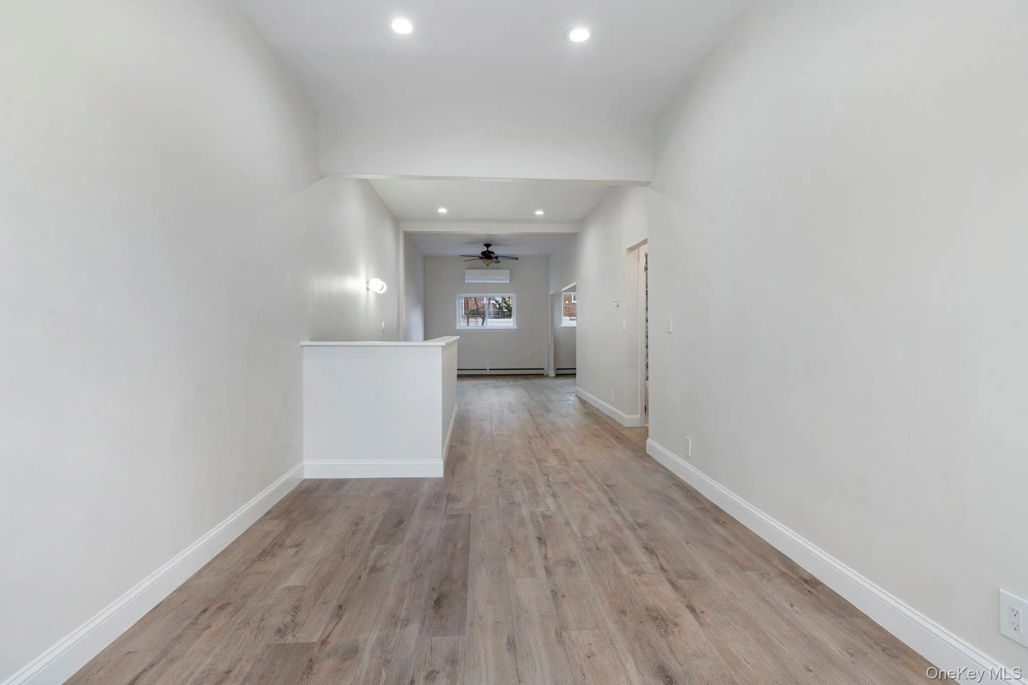 Hall with light wood-style flooring and recessed lighting Hall with light wood-style flooring and recessed lighting