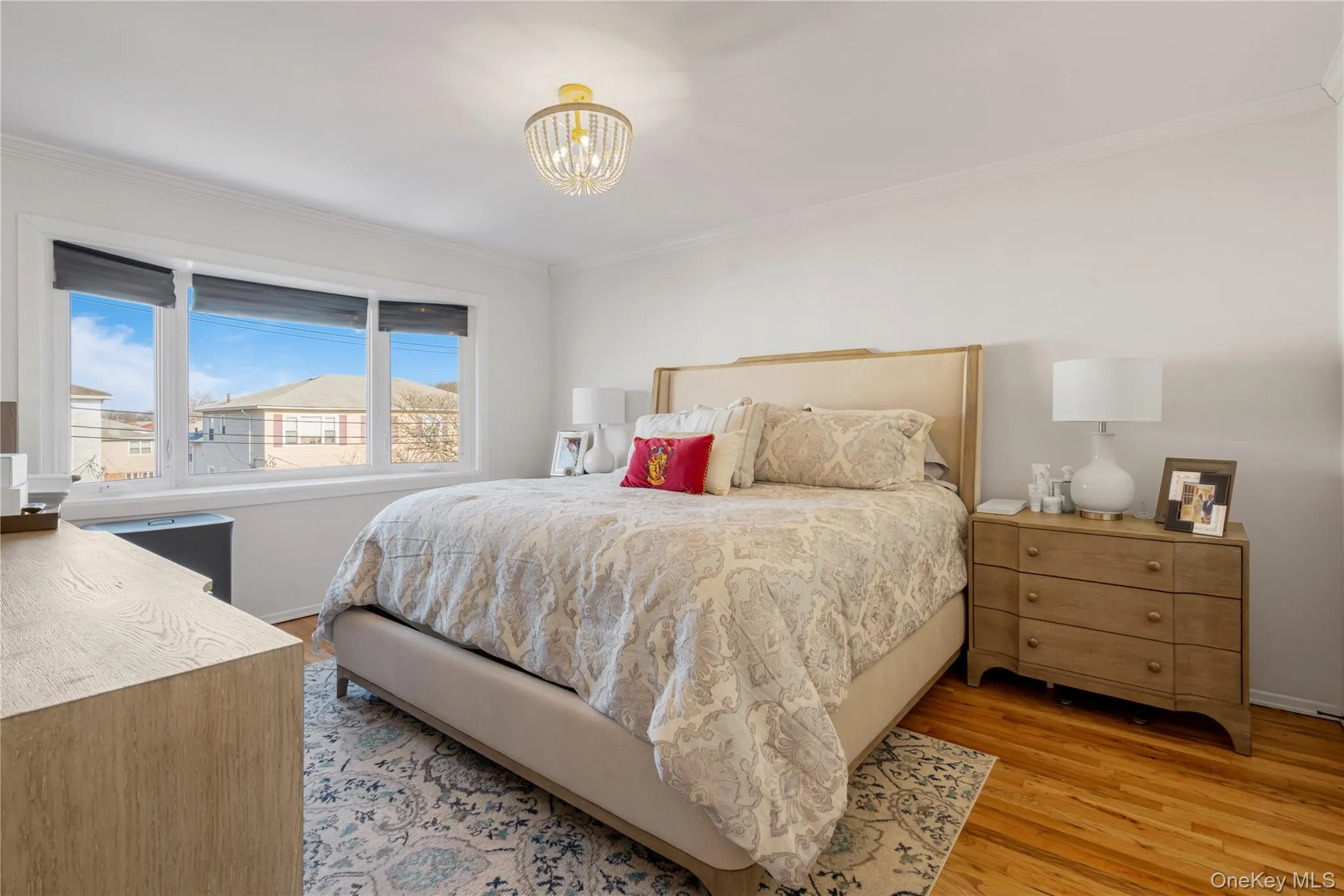 Bedroom with light wood-style floors, crown molding, and a chandelier Bedroom with light wood-style floors, crown molding, and a chandelier