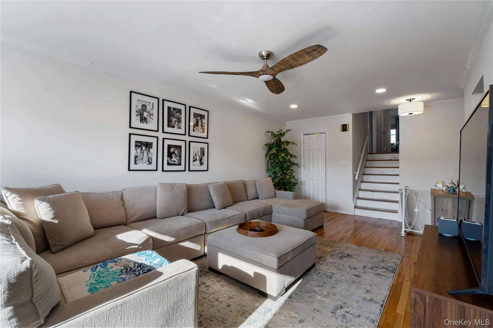 Living room featuring ornamental molding, stairway, hardwood / wood-style flooring, recessed lighting, and ceiling fan Living room featuring ornamental molding, stairway, hardwood / wood-style flooring, recessed lighting, and ceiling fan