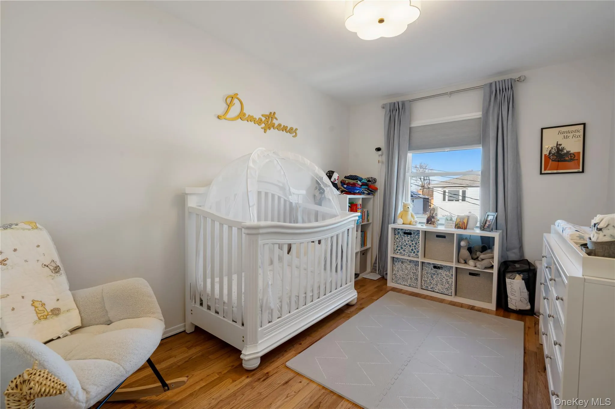 Bedroom featuring a nursery area and light wood finished floors Bedroom featuring a nursery area and light wood finished floors