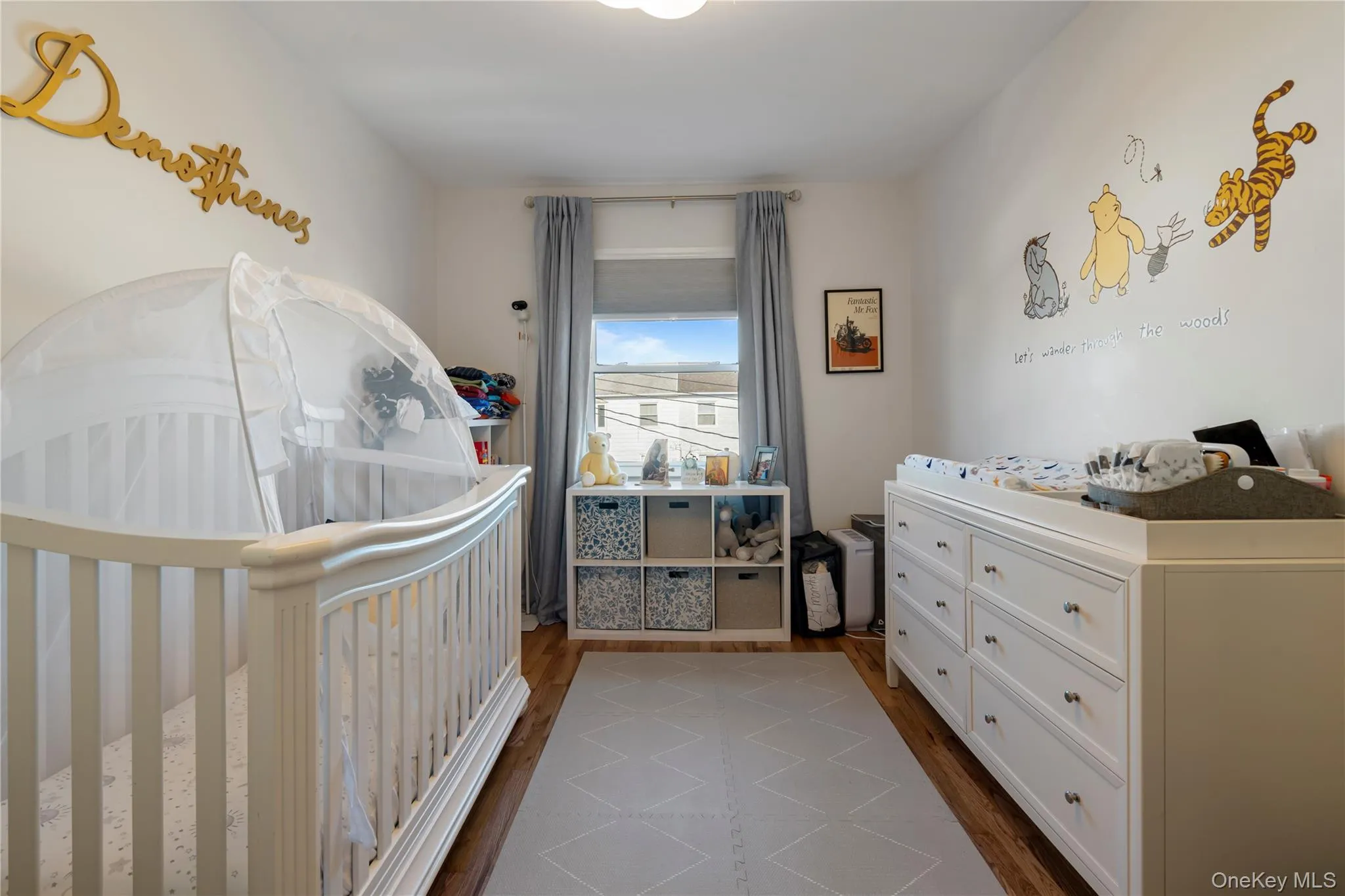 Bedroom with a nursery area and dark wood-type flooring Bedroom with a nursery area and dark wood-type flooring
