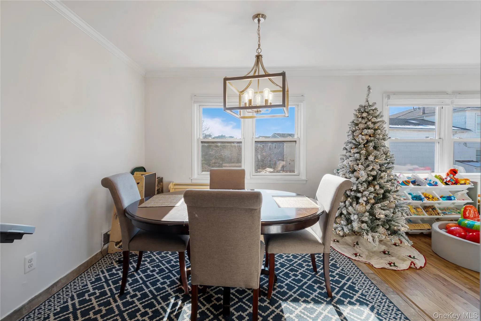 Dining area featuring ornamental molding, wood finished floors, and a chandelier Dining area featuring ornamental molding, wood finished floors, and a chandelier