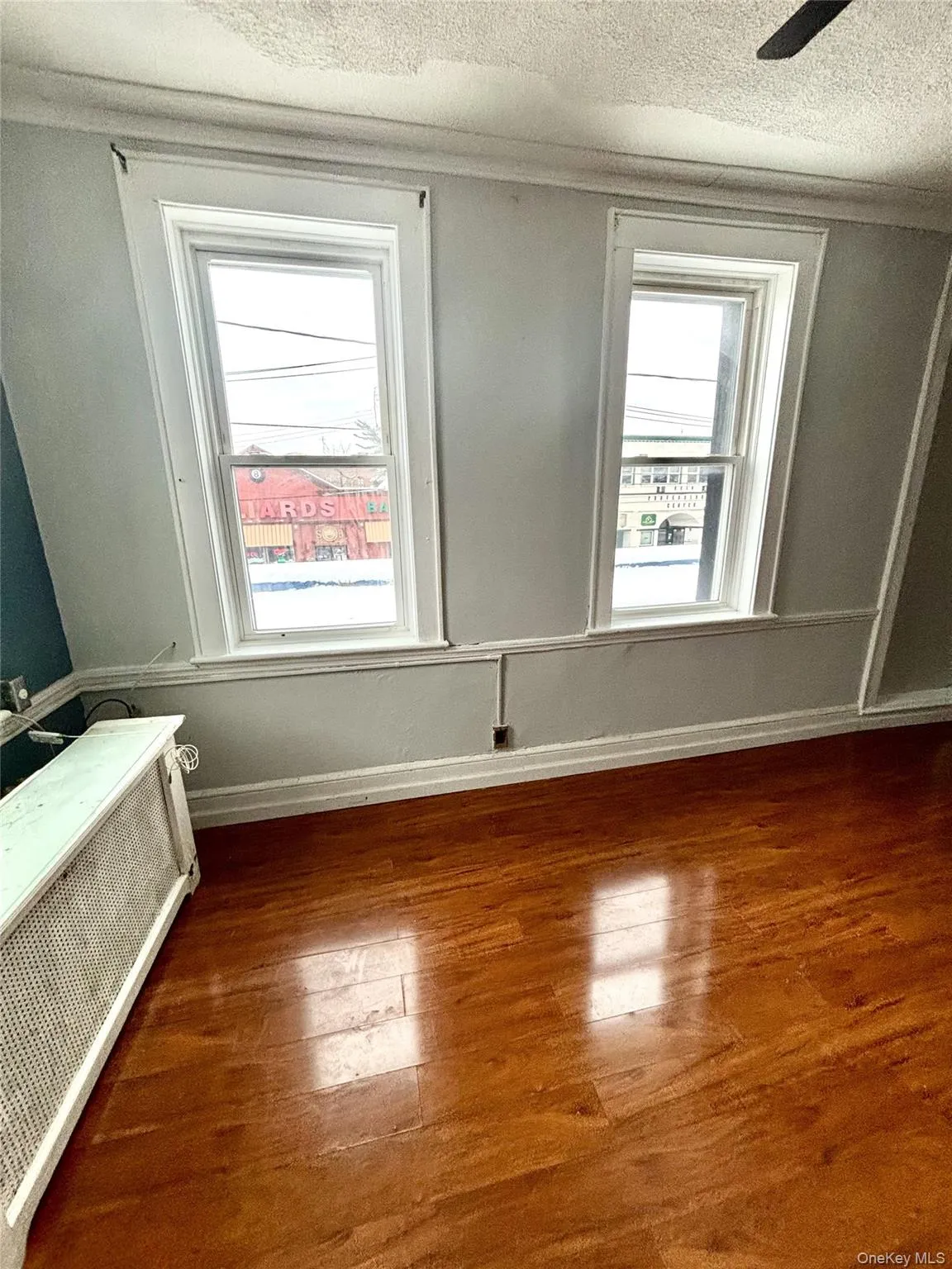 Bedroom with wood floors, a textured ceiling, crown molding, and healthy amount of natural light Bedroom with wood floors, a textured ceiling, crown molding, and healthy amount of natural light