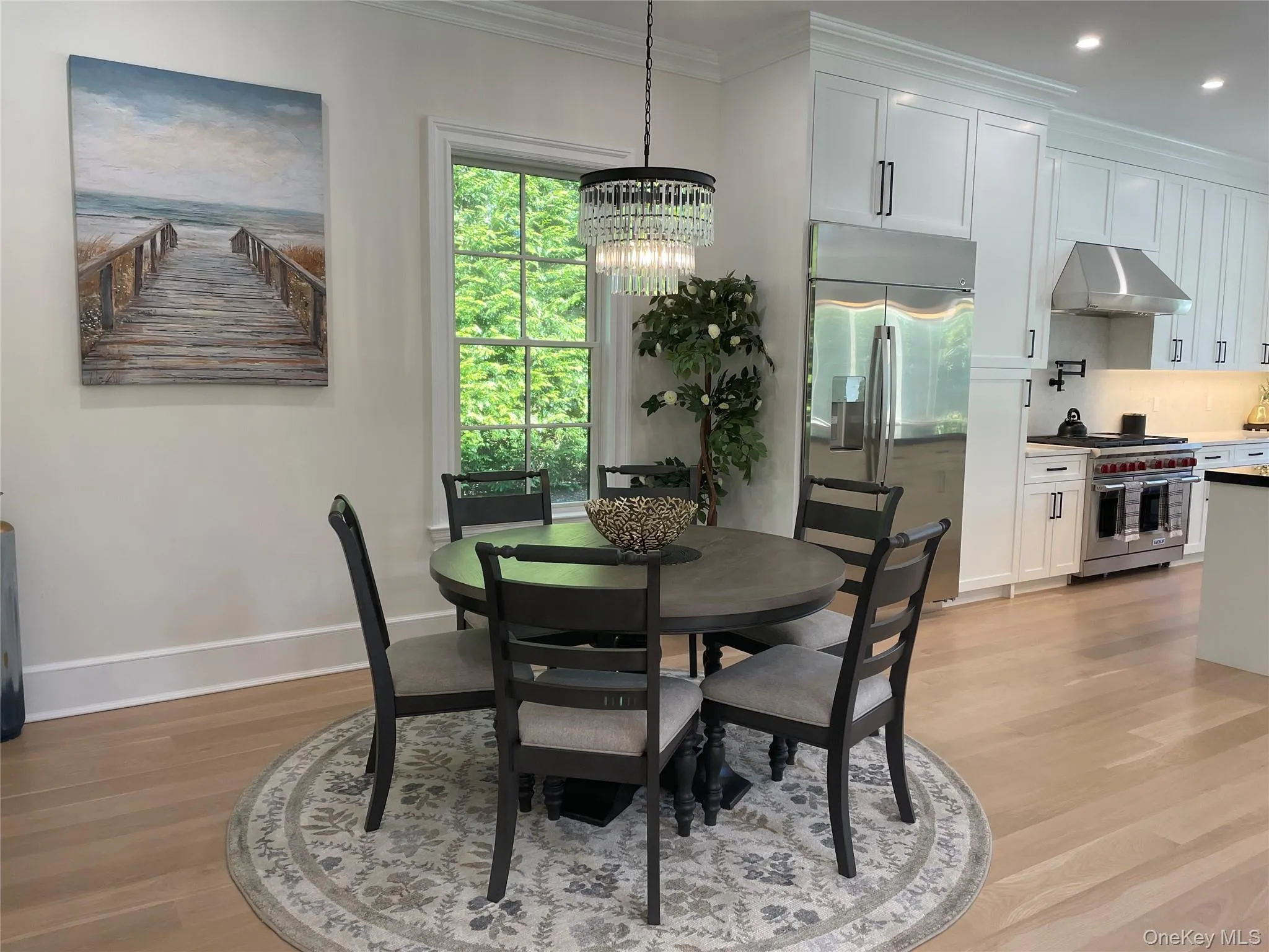 Dining area featuring light wood-style floors, ornamental molding, a chandelier, and recessed lighting Dining area featuring light wood-style floors, ornamental molding, a chandelier, and recessed lighting