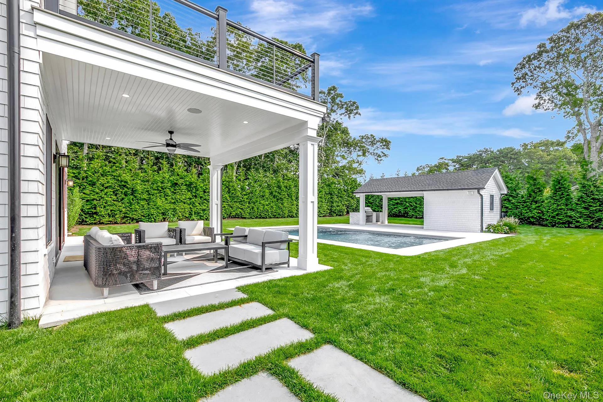 View of grassy yard with an outdoor pool, an outdoor structure, a patio area, an outdoor hangout area, and ceiling fan View of grassy yard with an outdoor pool, an outdoor structure, a patio area, an outdoor hangout area, and ceiling fan