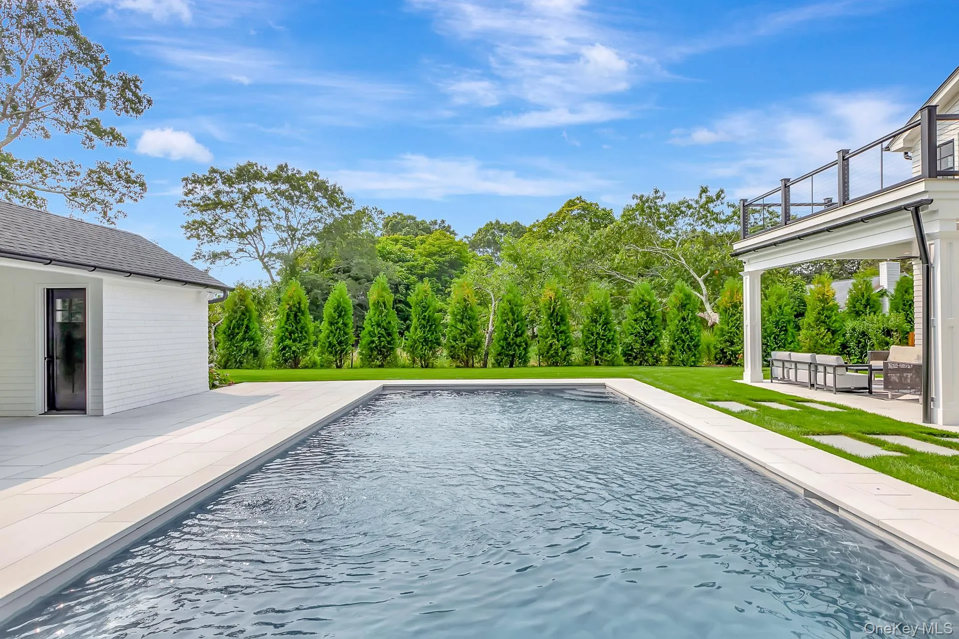 Outdoor pool with a patio and a lawn Outdoor pool with a patio and a lawn