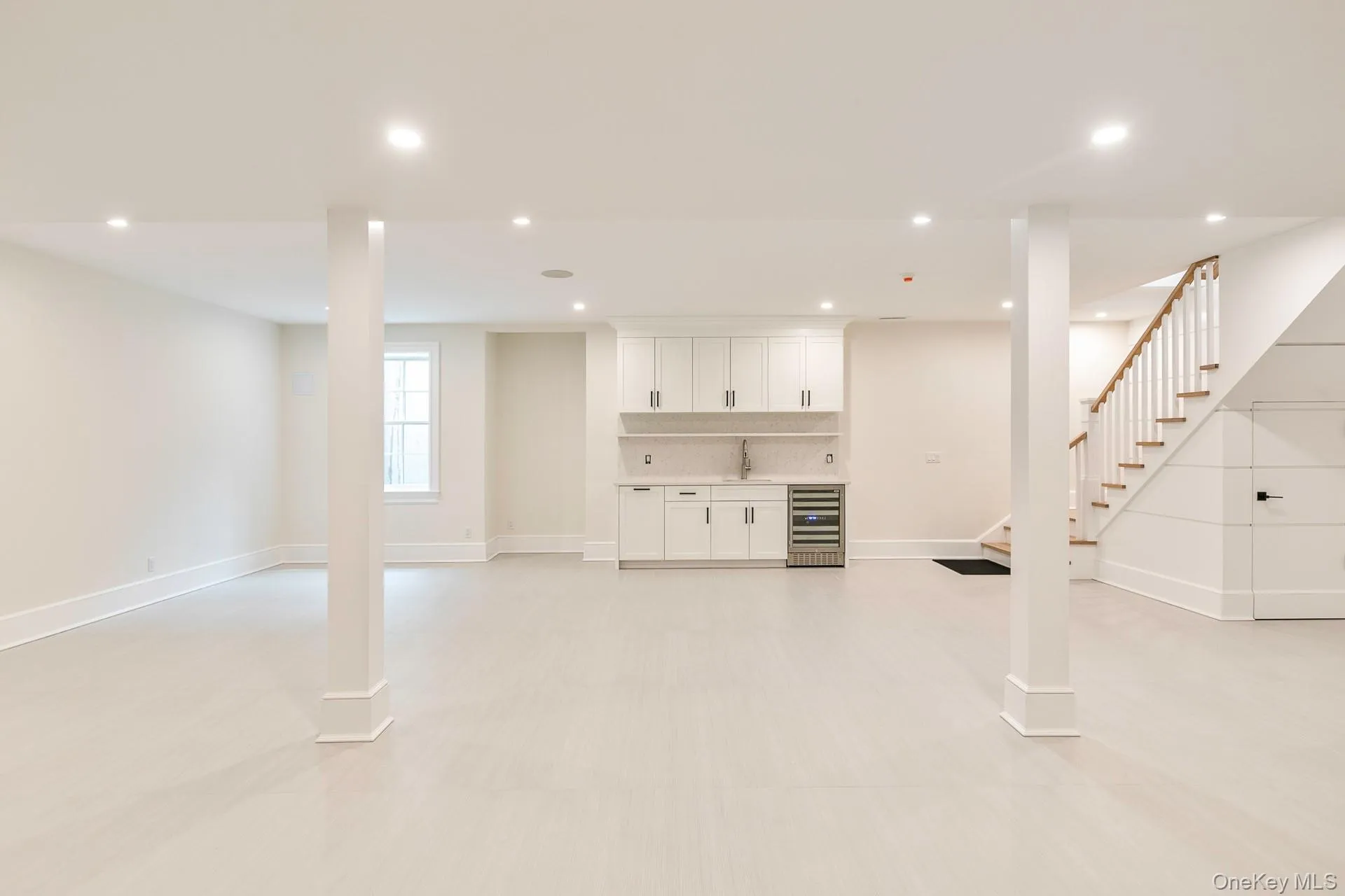 Basement featuring recessed lighting, bar with sink, and wine cooler Basement featuring recessed lighting, bar with sink, and wine cooler