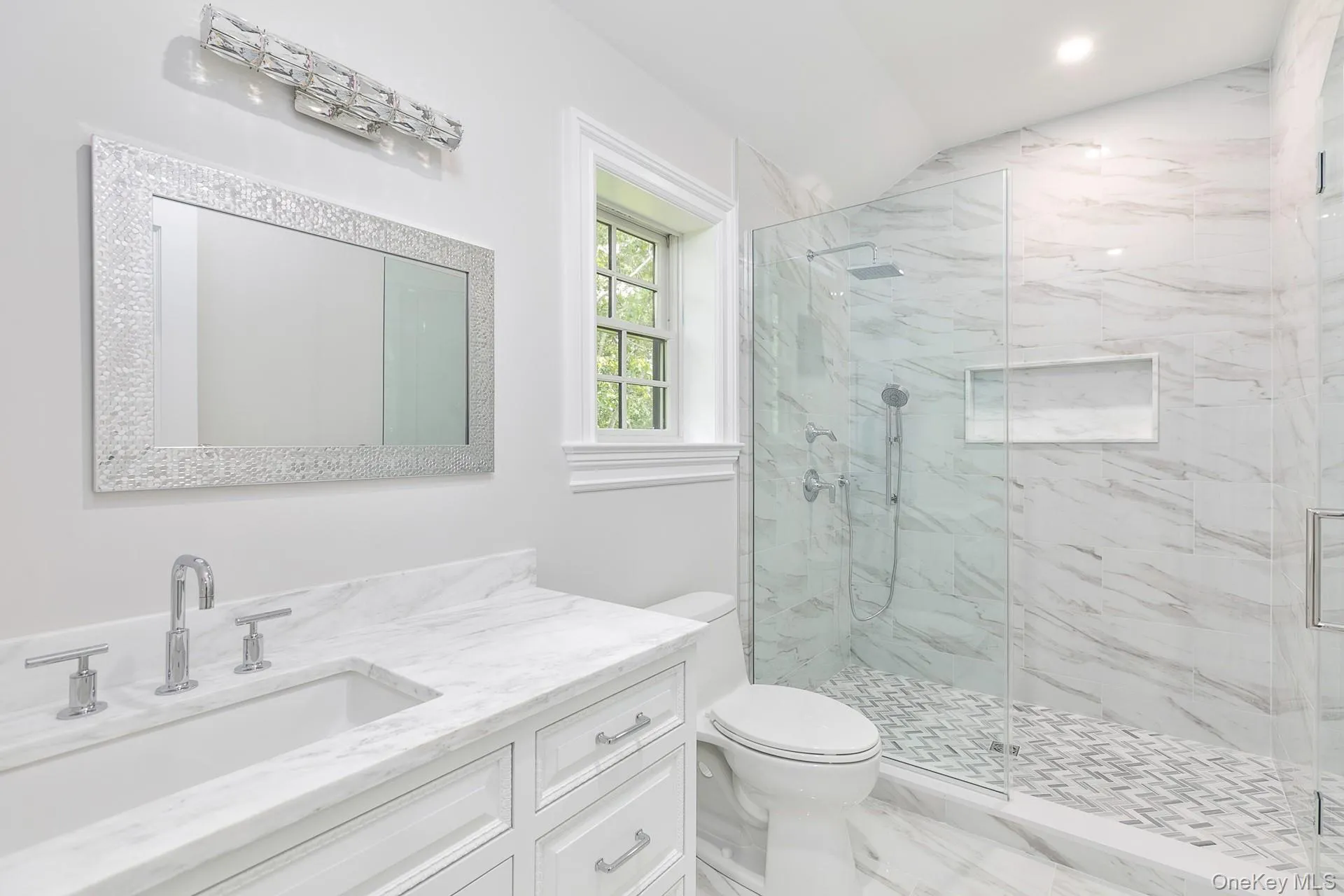 Bathroom featuring vanity, a marble finish shower, marble finish floors, and vaulted ceiling Bathroom featuring vanity, a marble finish shower, marble finish floors, and vaulted ceiling