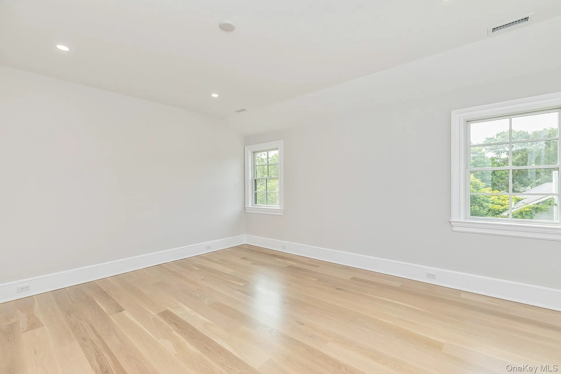 Unfurnished room with light wood-style flooring, recessed lighting, and lofted ceiling Unfurnished room with light wood-style flooring, recessed lighting, and lofted ceiling