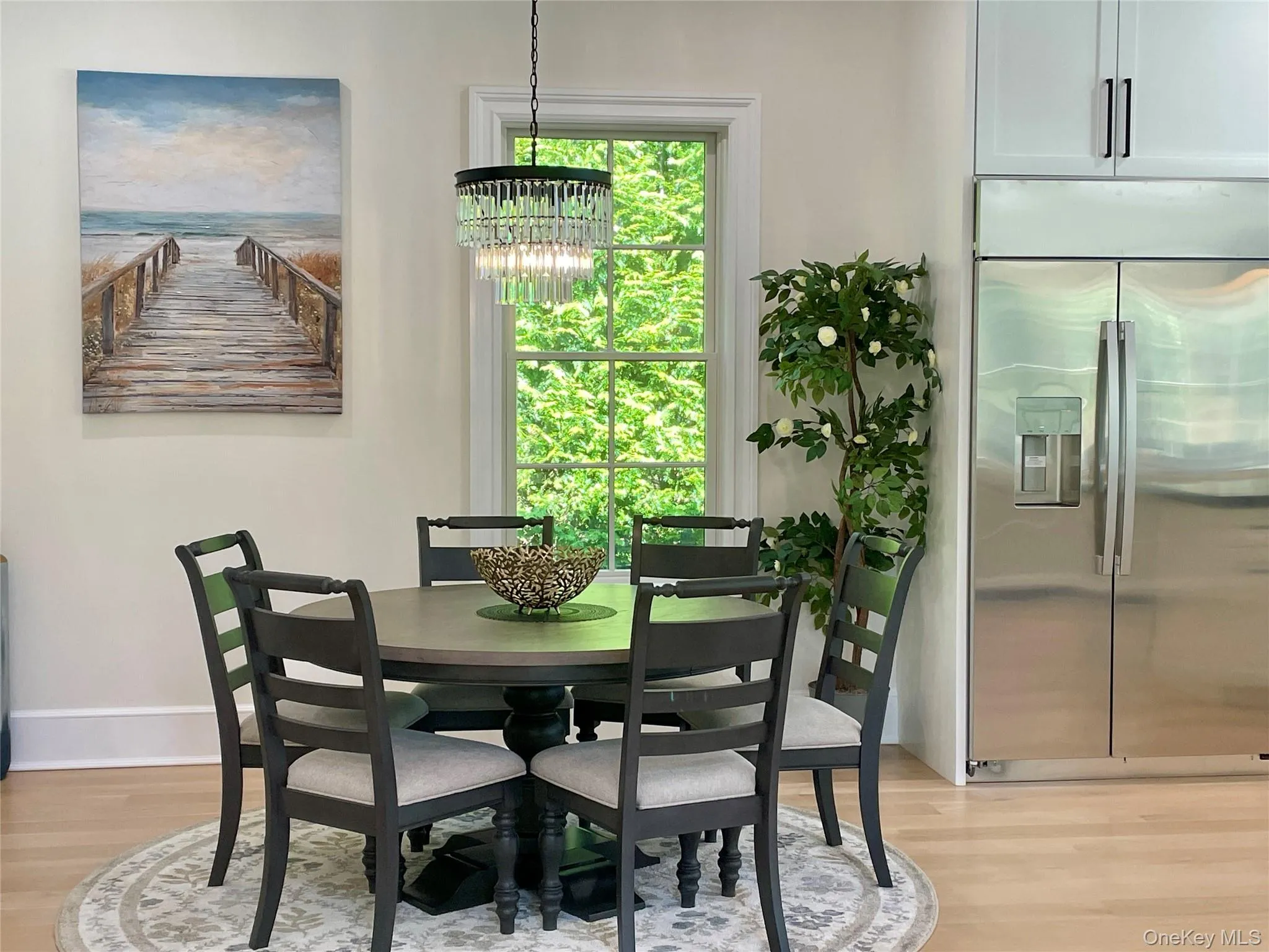 Dining space with light wood finished floors, plenty of natural light, and a chandelier Dining space with light wood finished floors, plenty of natural light, and a chandelier