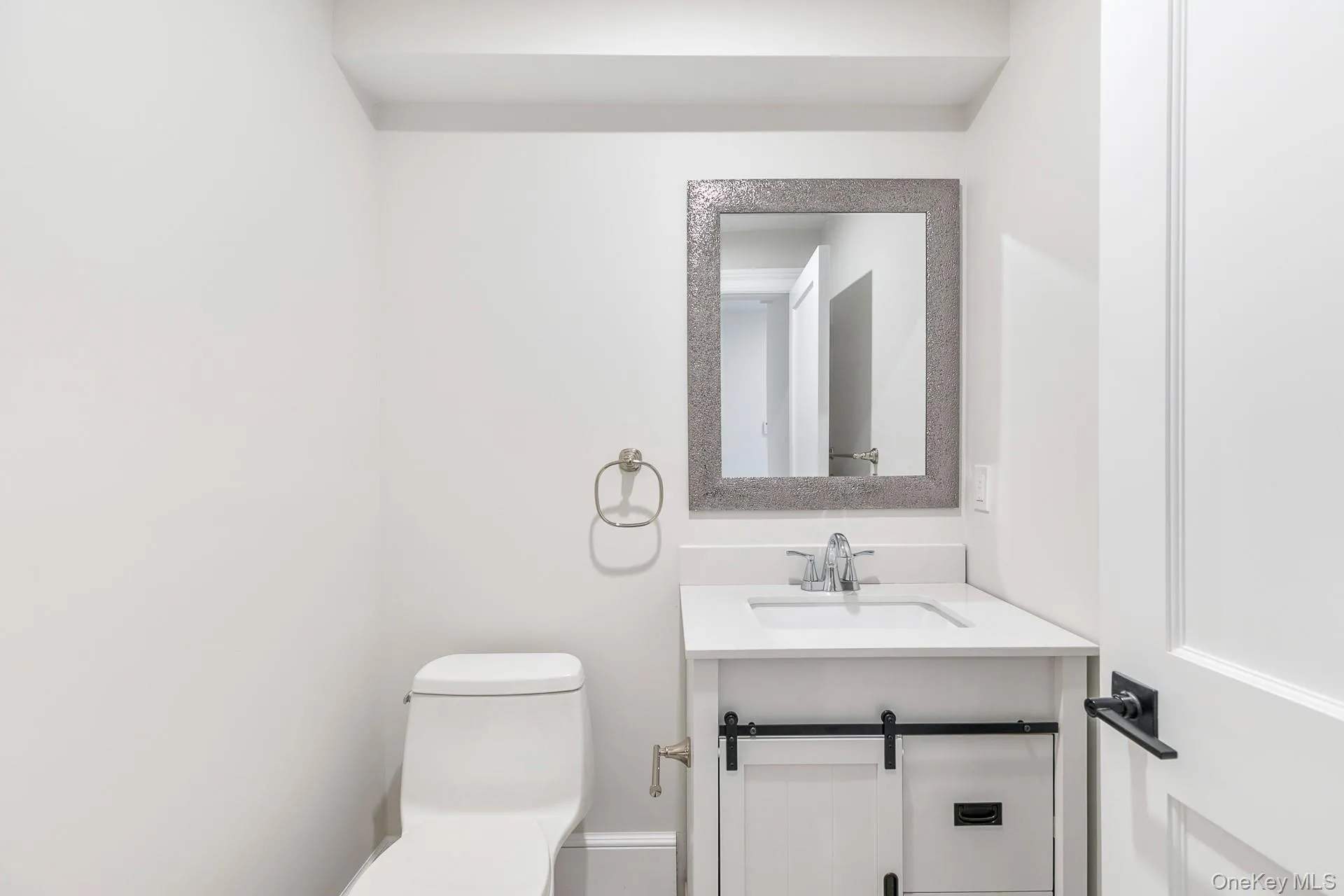 Half bath featuring vanity and toilet Half bath featuring vanity and toilet