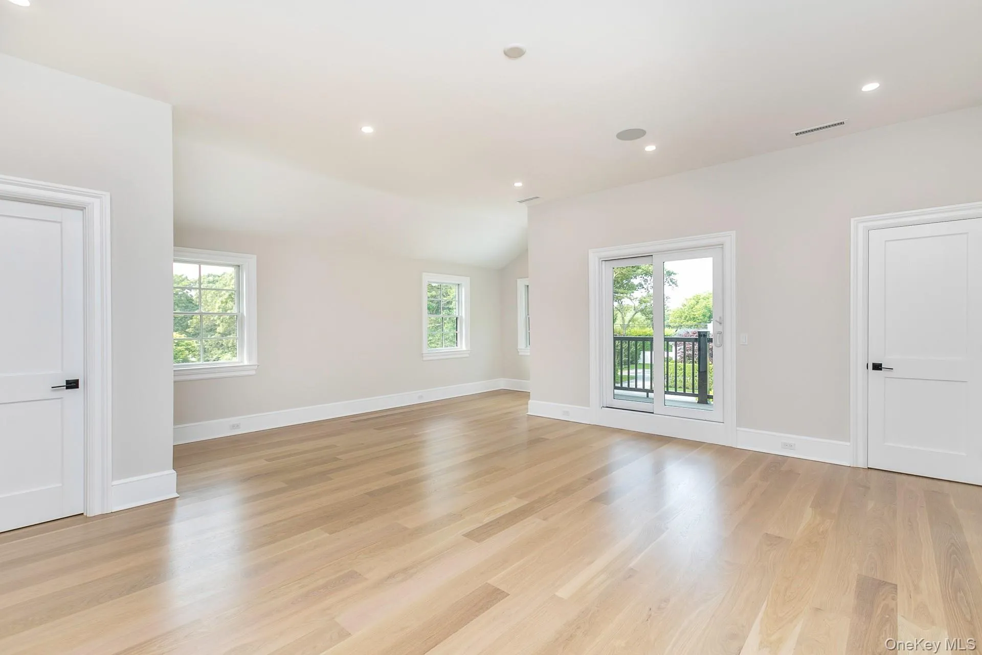 Empty room featuring lofted ceiling, healthy amount of natural light, light wood-type flooring, and recessed lighting Empty room featuring lofted ceiling, healthy amount of natural light, light wood-type flooring, and recessed lighting