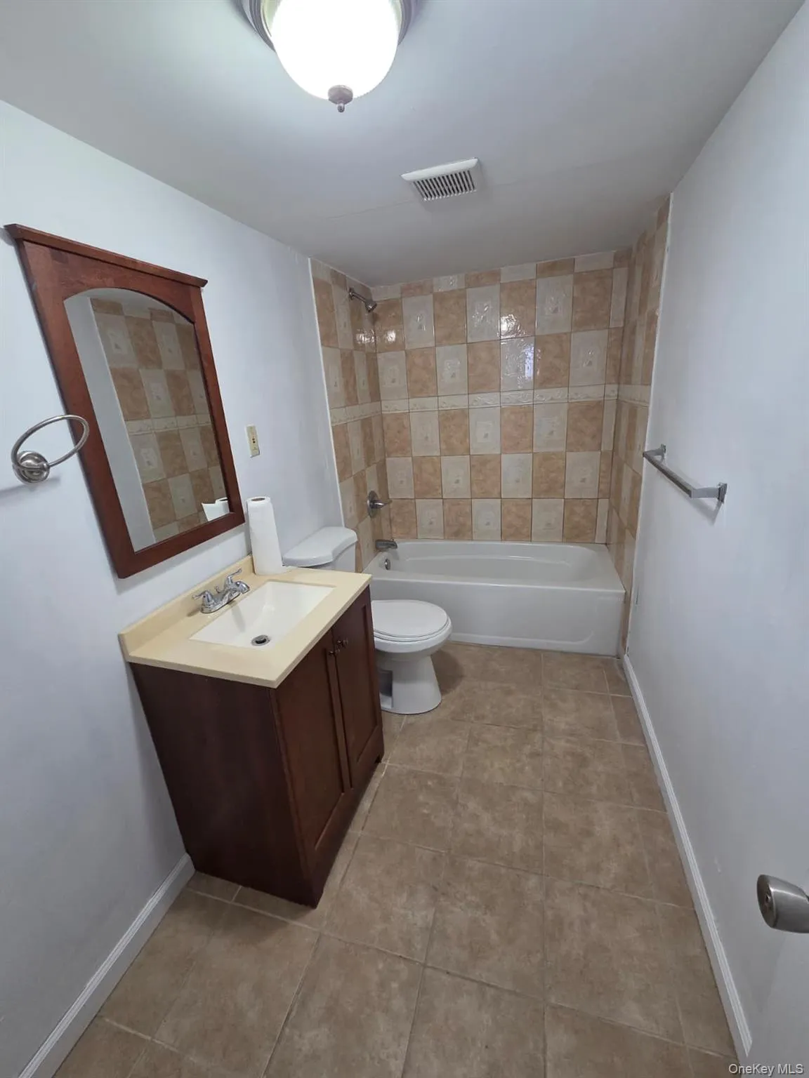 Full bathroom with vanity, shower / bathtub combination, and light tile patterned floors Full bathroom with vanity, shower / bathtub combination, and light tile patterned floors