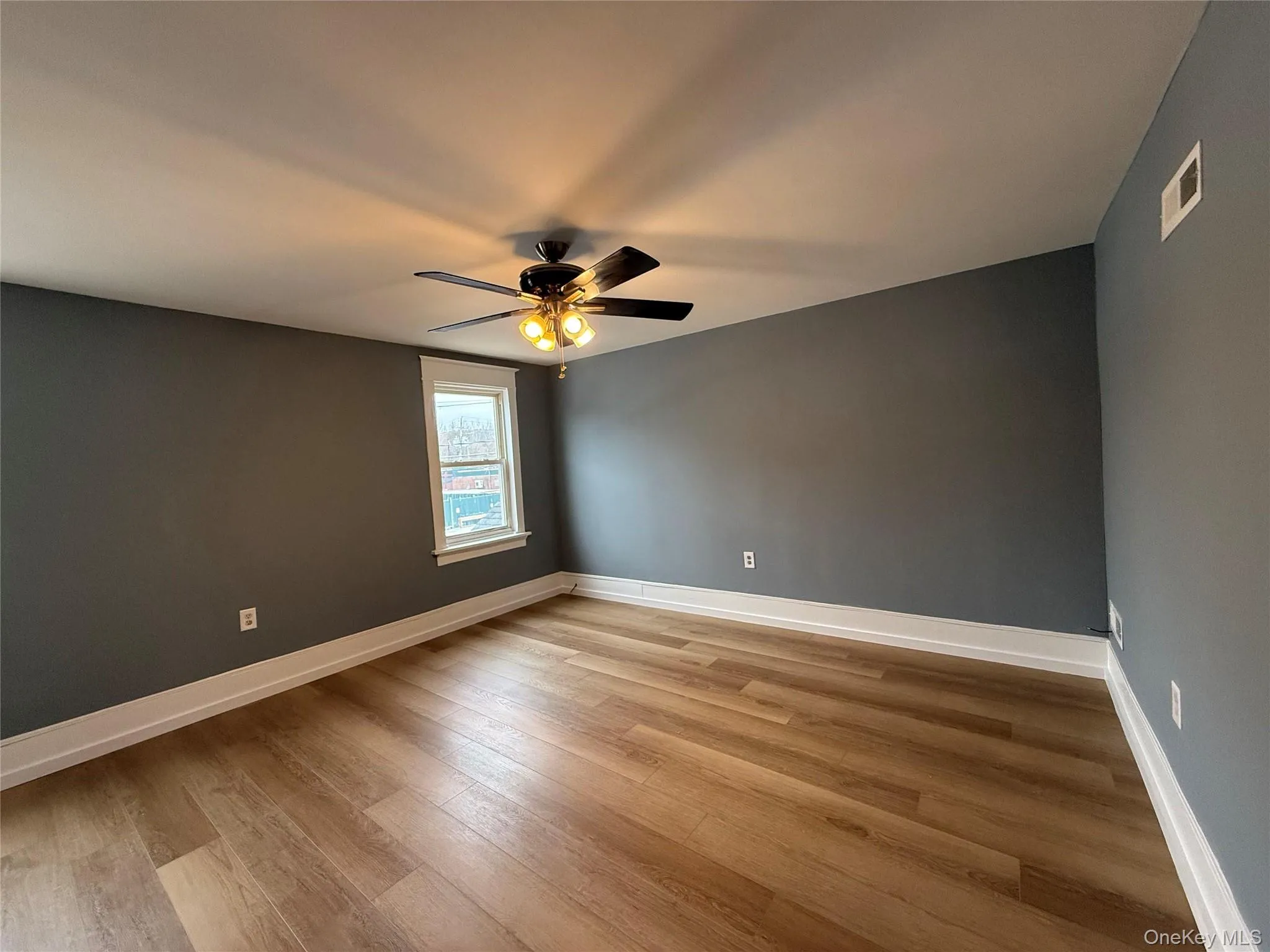 Empty room featuring light wood-style flooring and a ceiling fan Empty room featuring light wood-style flooring and a ceiling fan