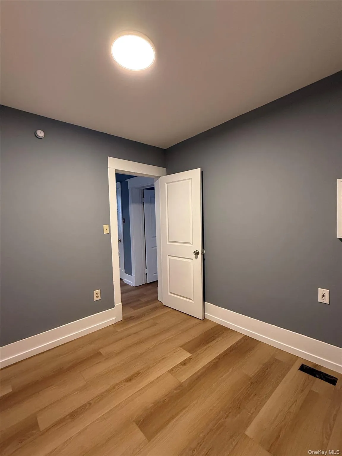 Unfurnished room with baseboards and wood finished floors Unfurnished room with baseboards and wood finished floors