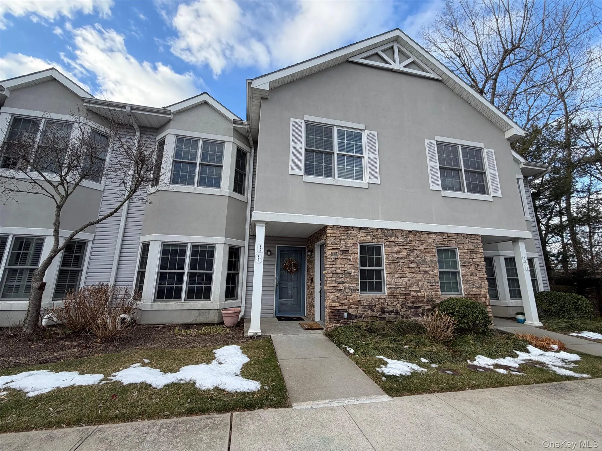 Traditional-style house featuring stucco siding and stone siding Traditional-style house featuring stucco siding and stone siding