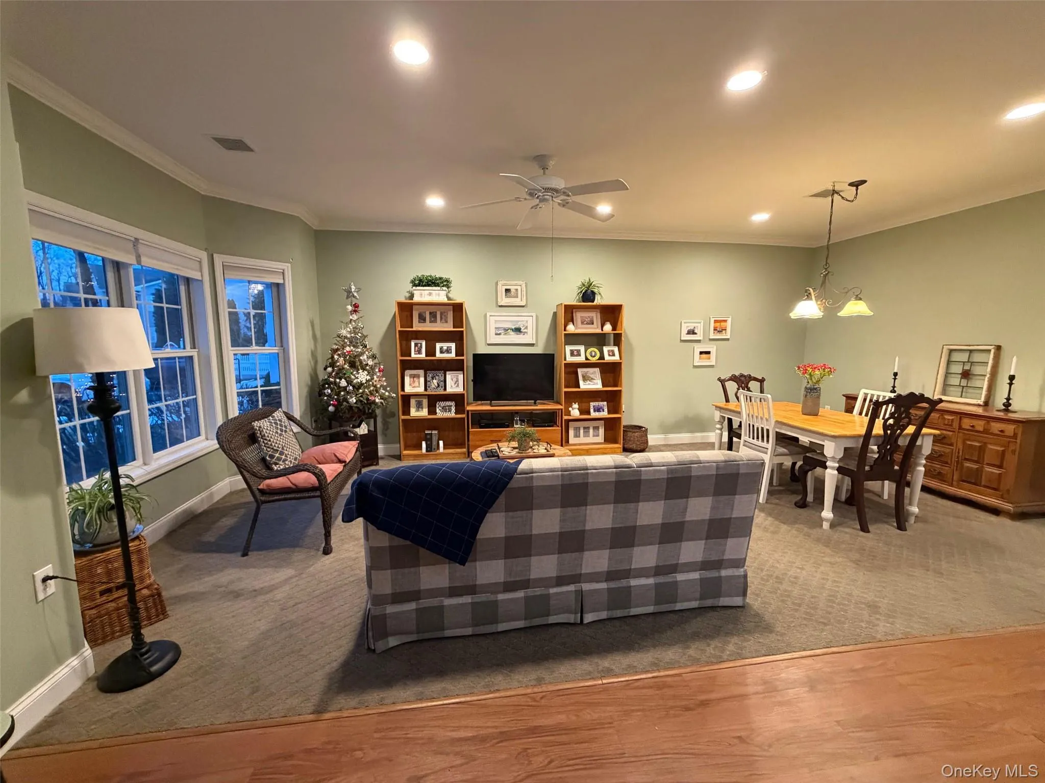 Living room with crown molding, ceiling fan, recessed lighting, carpet floors, and wood finished floors Living room with crown molding, ceiling fan, recessed lighting, carpet floors, and wood finished floors