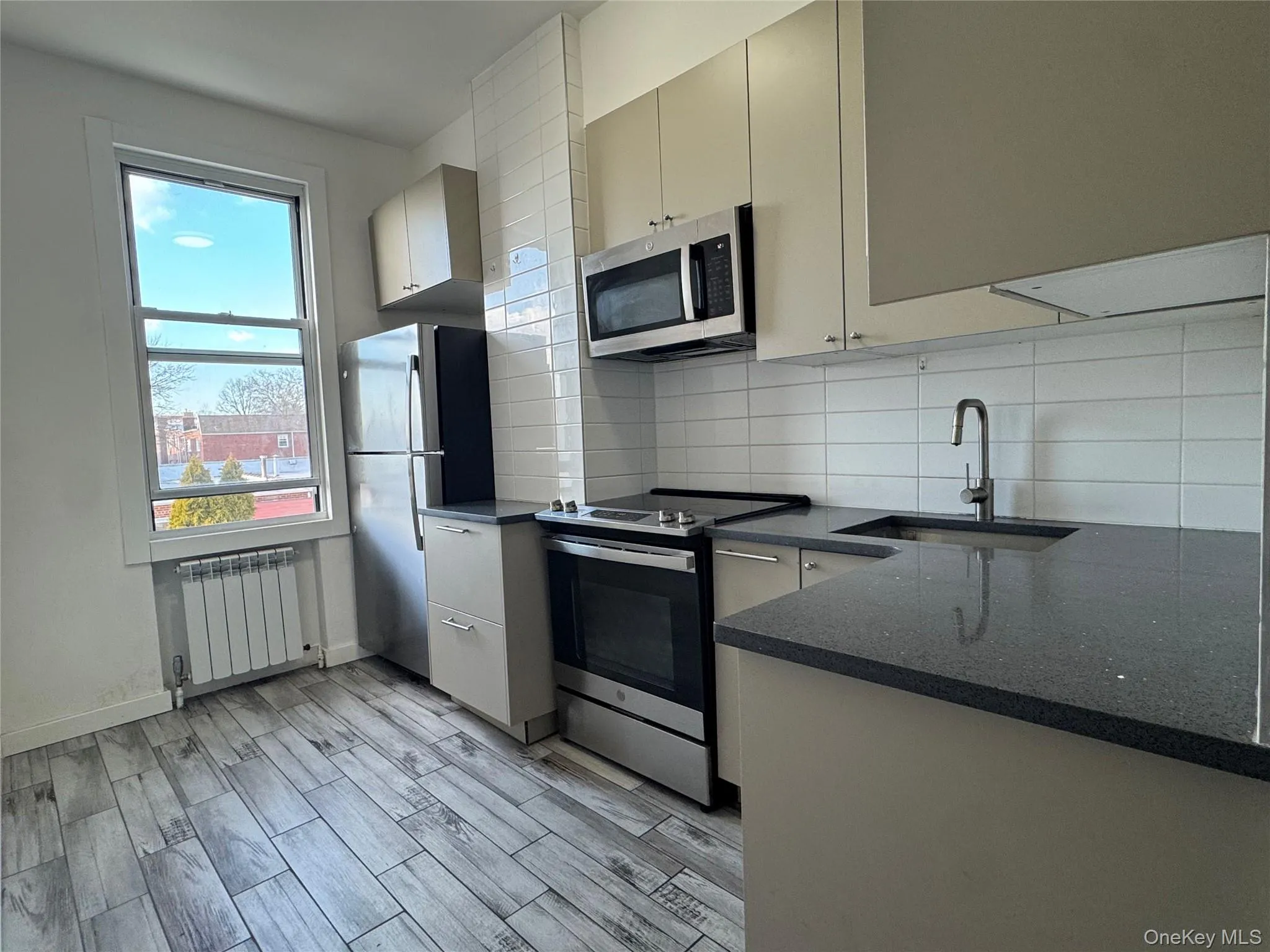 Kitchen featuring quartz countertops and a large size window Kitchen featuring quartz countertops and a large size window
