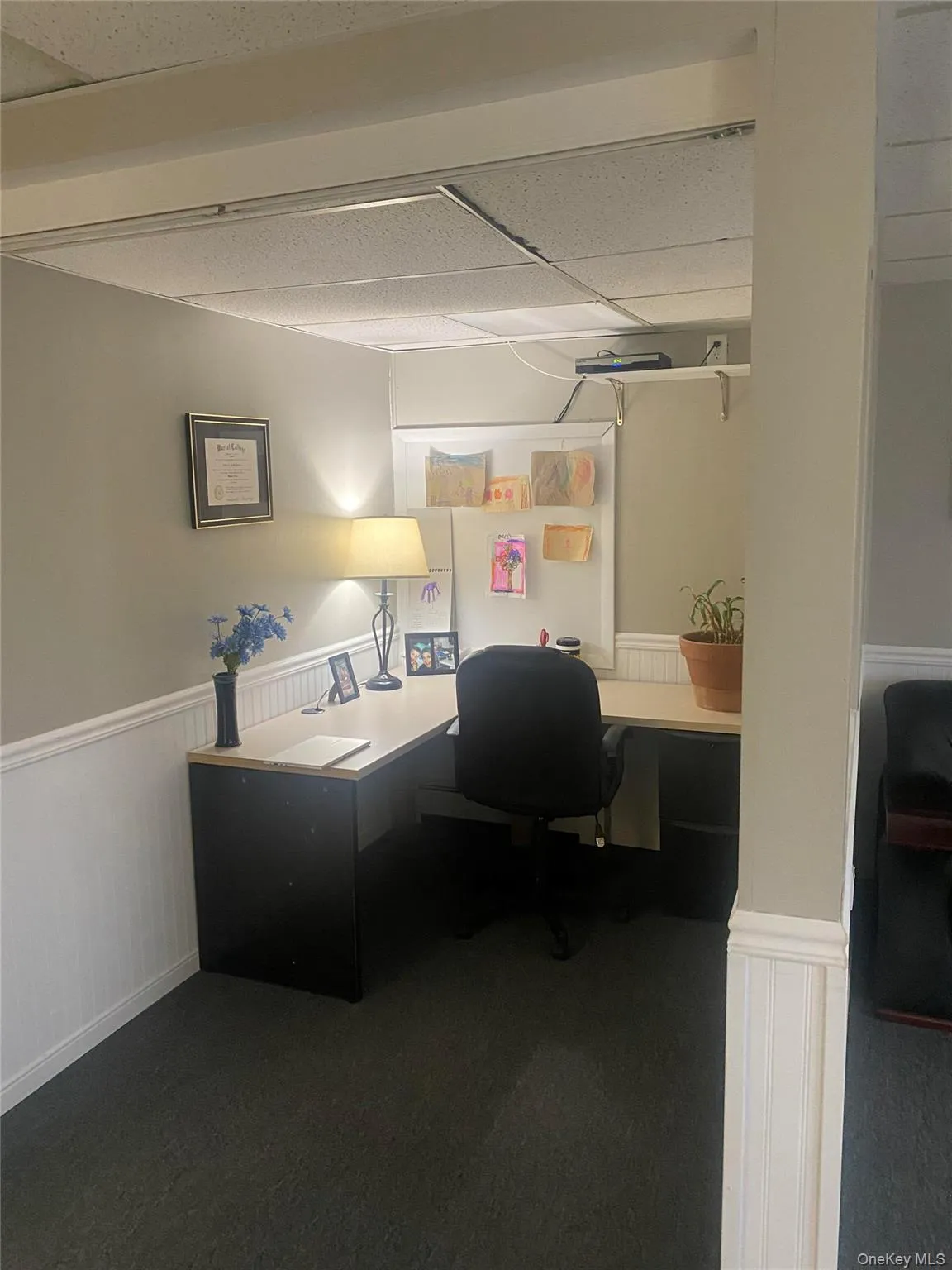Home office featuring wainscoting, a drop ceiling, and built in desk Home office featuring wainscoting, a drop ceiling, and built in desk