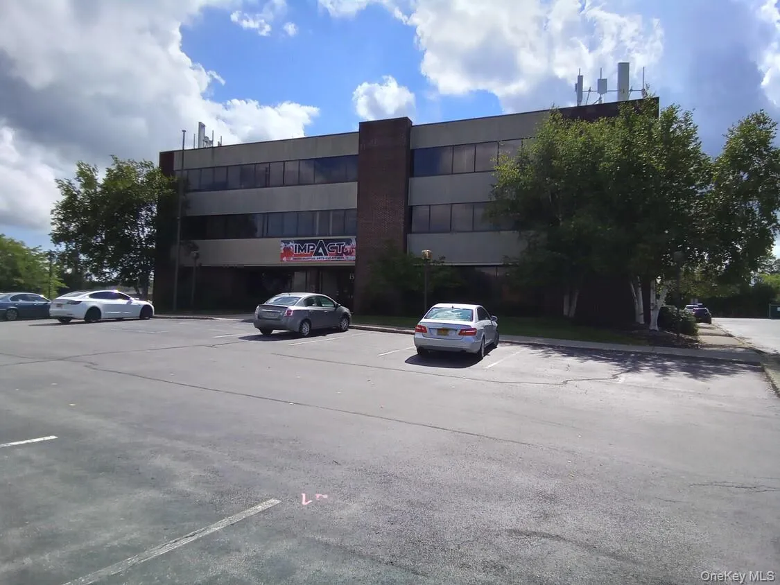 View of commercial property with uncovered parking View of commercial property with uncovered parking