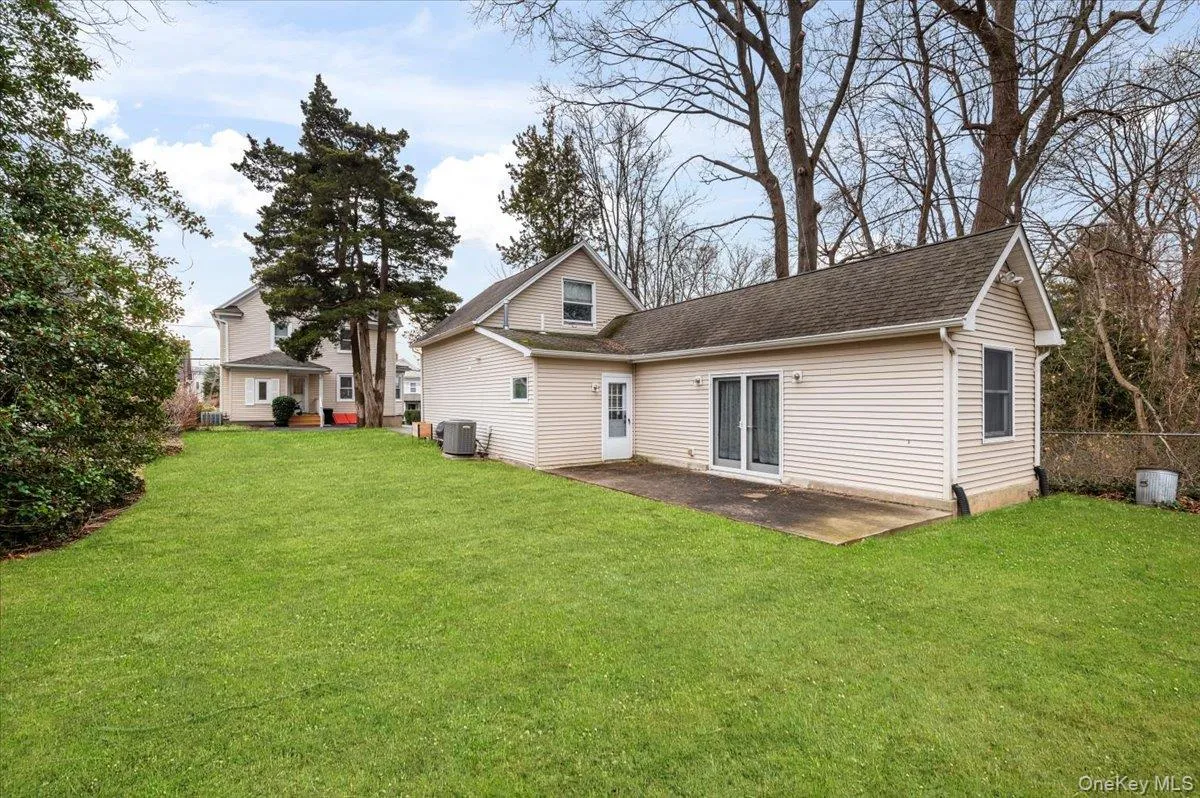 Back of house featuring a yard, a patio, and roof with shingles Back of house featuring a yard, a patio, and roof with shingles