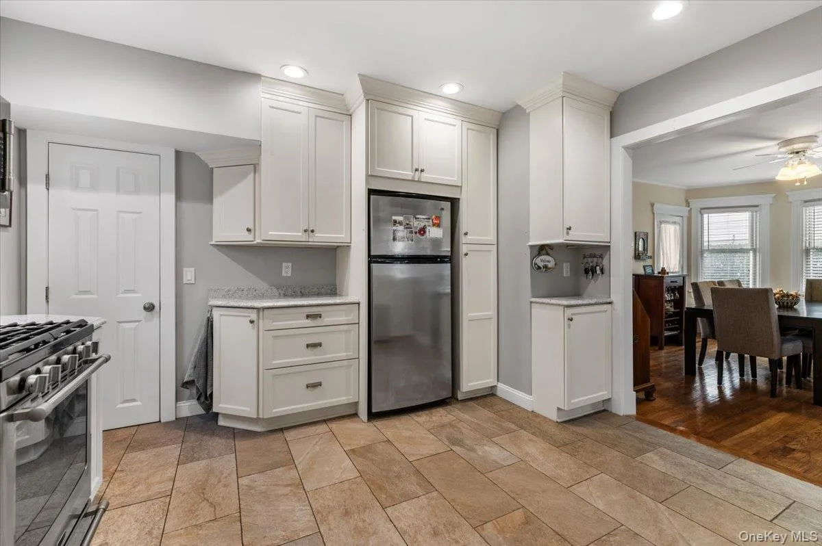 Kitchen featuring appliances with stainless steel finishes, white cabinets, ceiling fan, light stone counters, and recessed lighting Kitchen featuring appliances with stainless steel finishes, white cabinets, ceiling fan, light stone counters, and recessed lighting