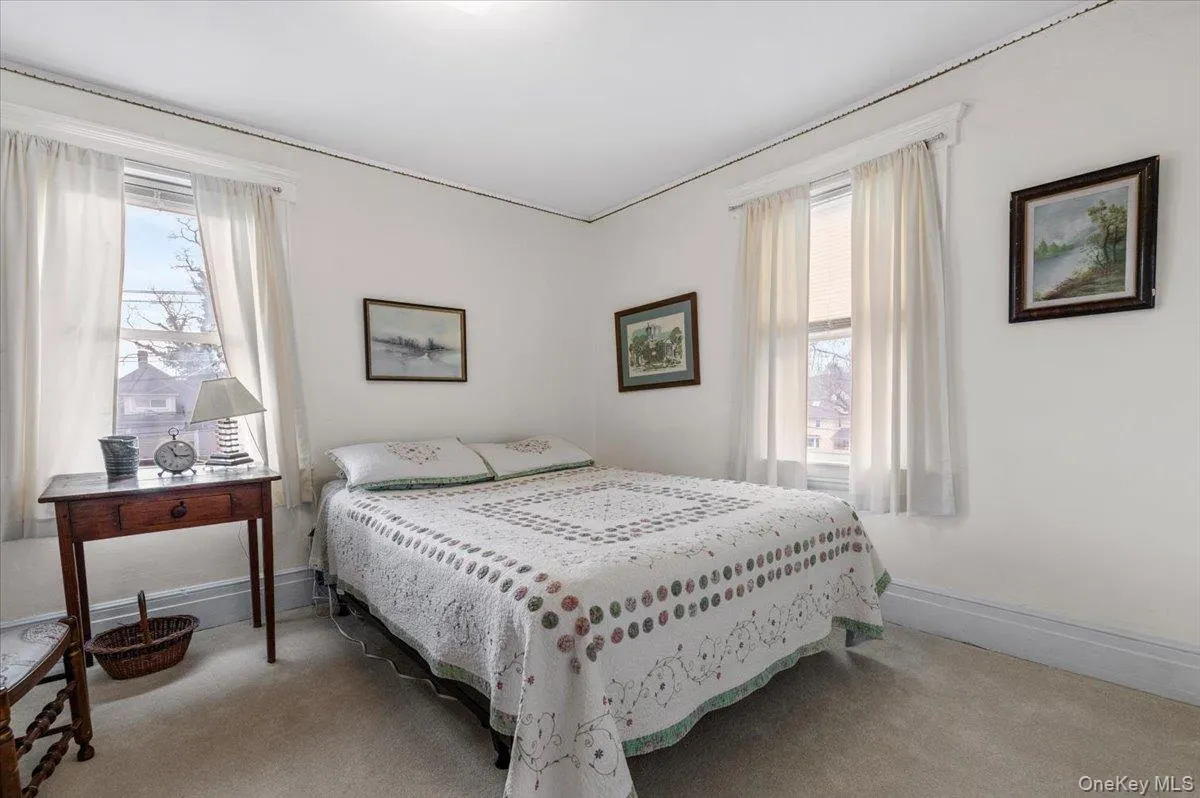 Carpeted bedroom featuring multiple windows Carpeted bedroom featuring multiple windows