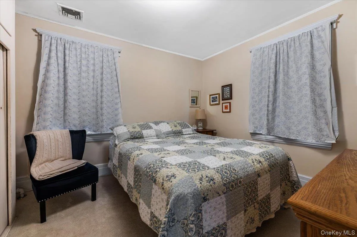 Carpeted bedroom with crown molding and baseboards Carpeted bedroom with crown molding and baseboards
