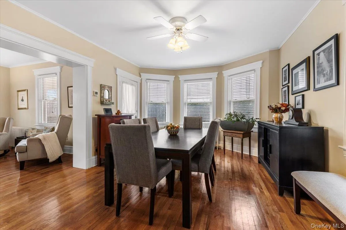 Dining area featuring ornamental molding, dark wood-style floors, healthy amount of natural light, and ceiling fan Dining area featuring ornamental molding, dark wood-style floors, healthy amount of natural light, and ceiling fan