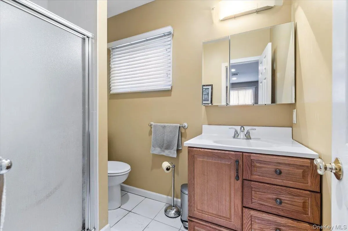 Full bathroom featuring vanity, a shower stall, and light tile patterned floors Full bathroom featuring vanity, a shower stall, and light tile patterned floors