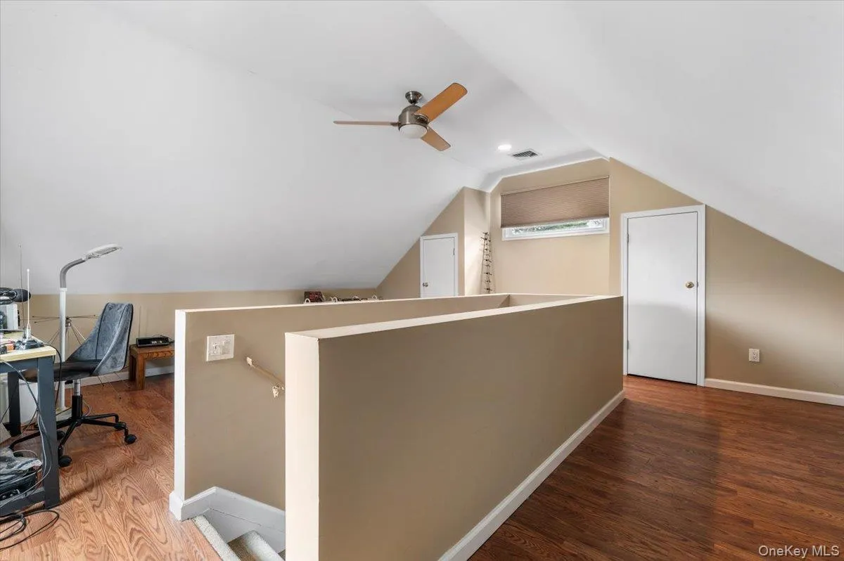Office space with dark wood finished floors, lofted ceiling, and a ceiling fan Office space with dark wood finished floors, lofted ceiling, and a ceiling fan