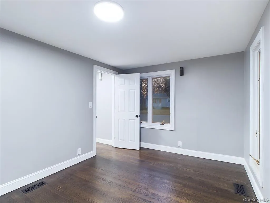 Unfurnished bedroom featuring dark wood-type flooring and baseboards Unfurnished bedroom featuring dark wood-type flooring and baseboards